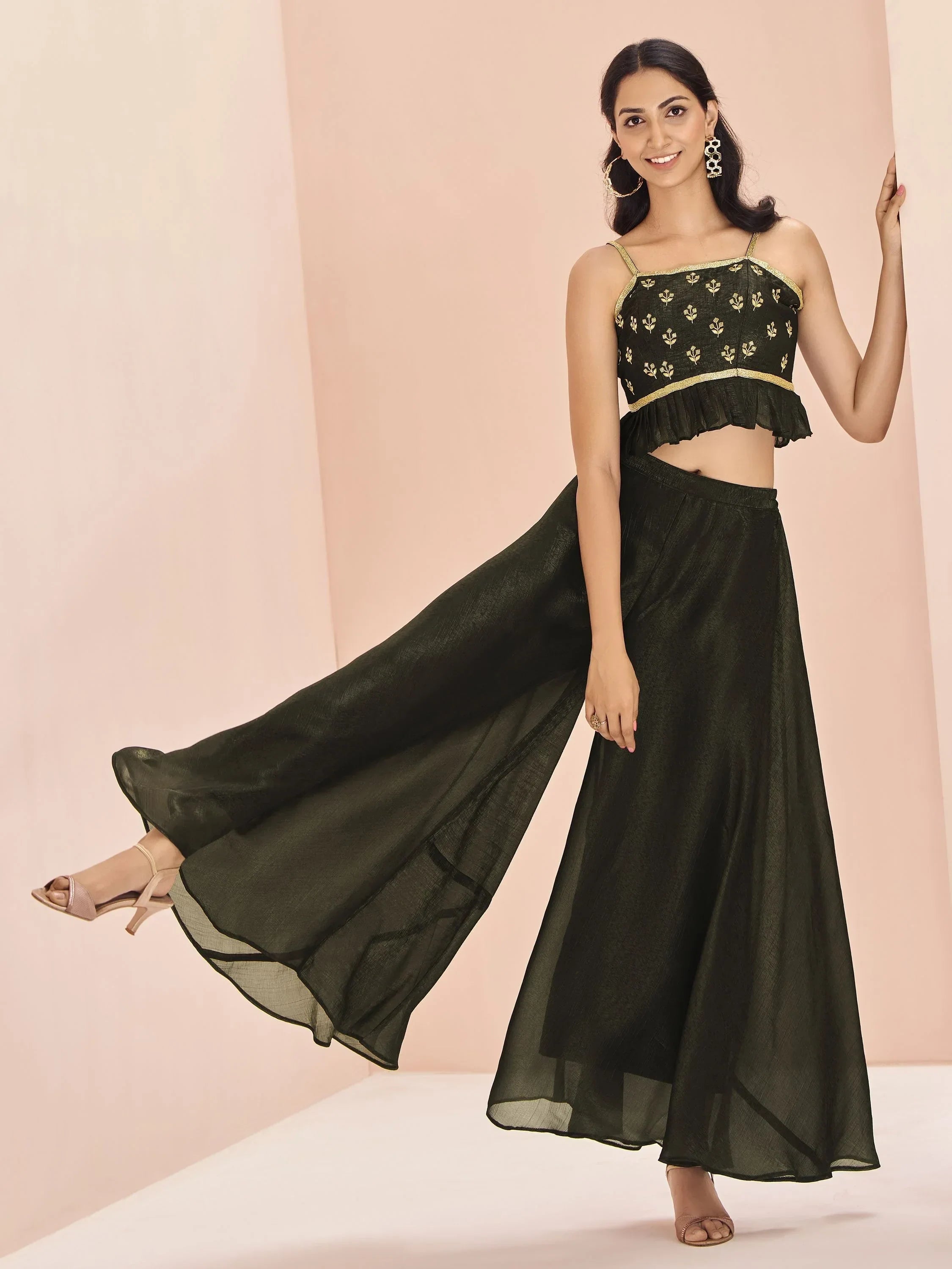 Woman in stylish dark green lehenga choli with floral embroidery and flared skirt