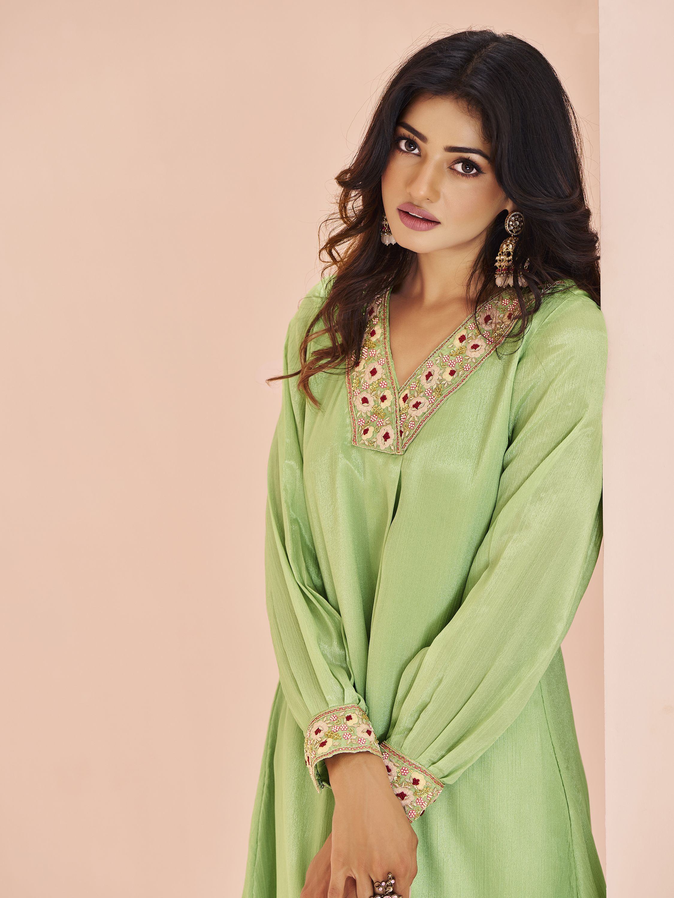 Woman in light green ethnic kurta with embroidered neckline and cuffs, posing indoors