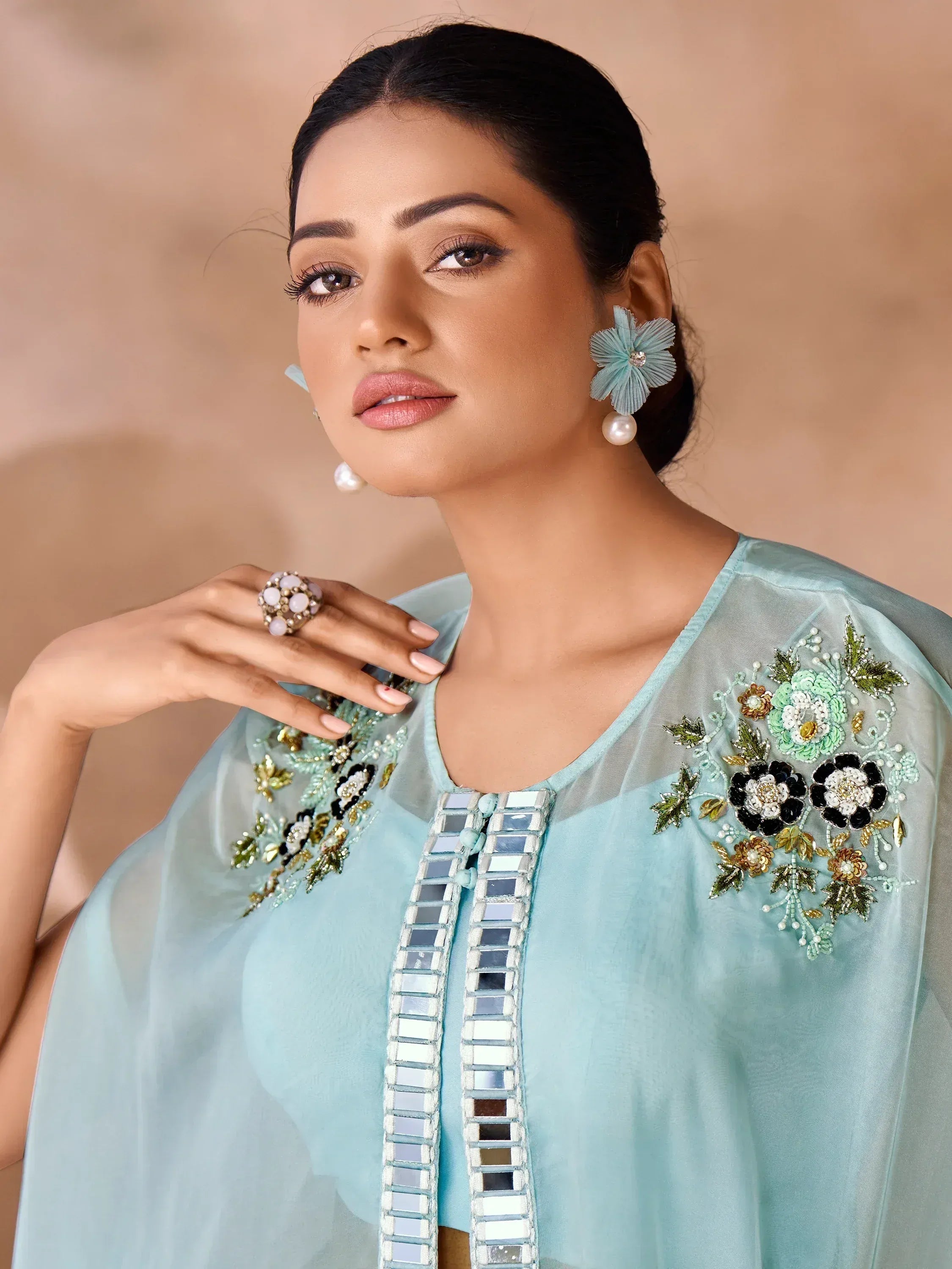 Light blue ethnic kurta with floral embroidery and mirror work, paired with pearl earrings