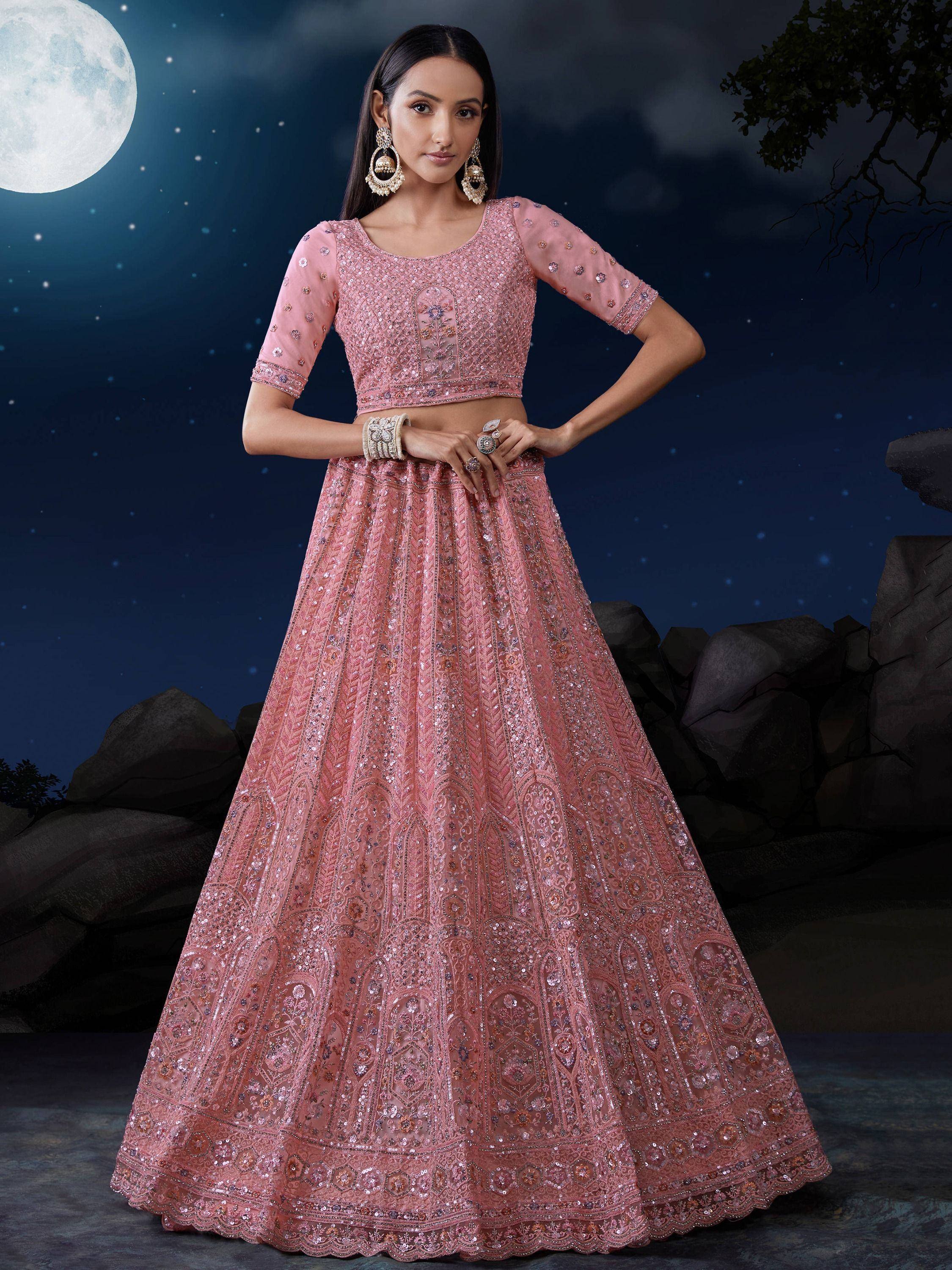 Pink embroidered lehenga choli with sequins, perfect for Indian weddings or festive occasions under moonlight.