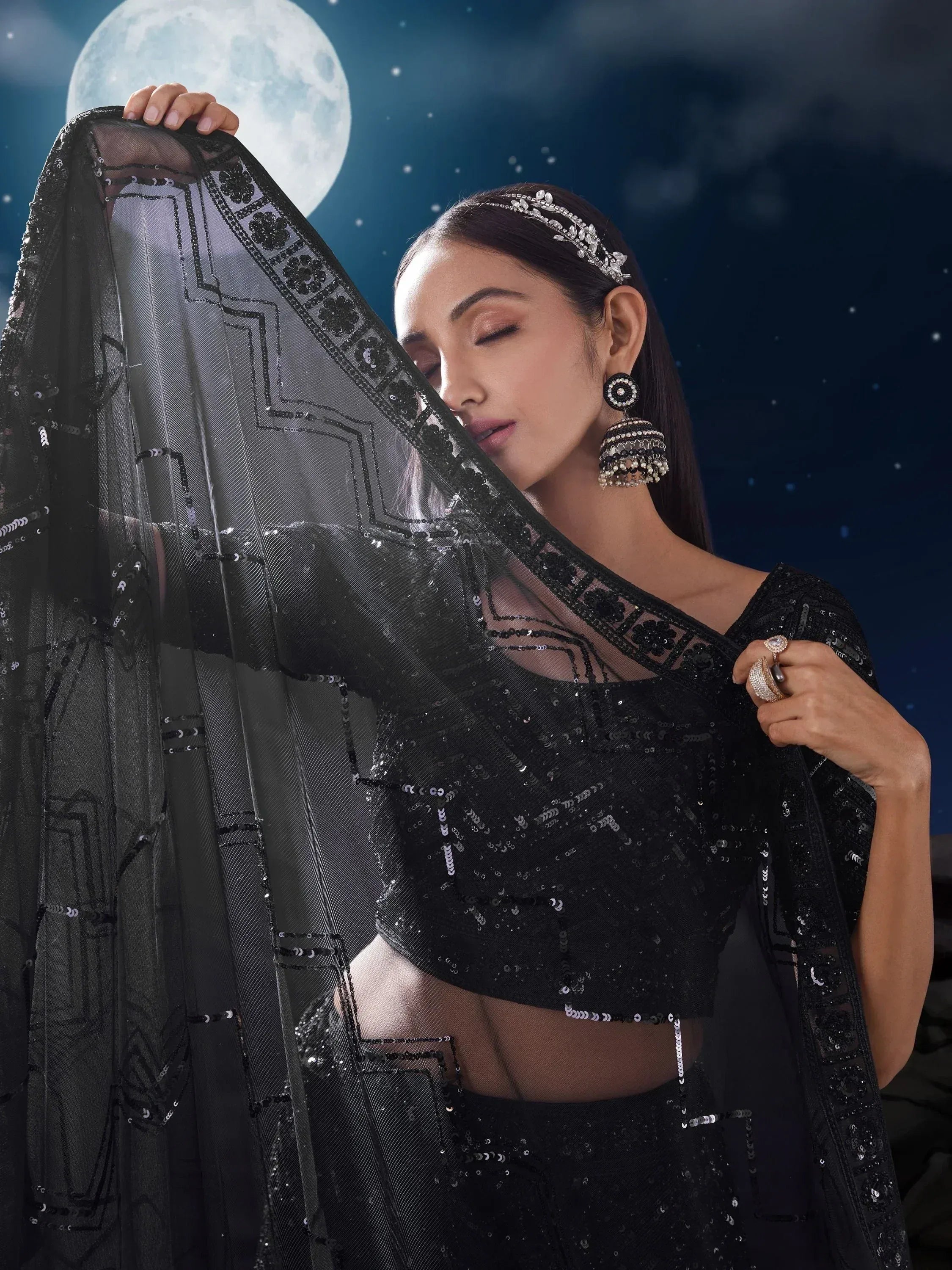 Elegant black sequin lehenga choli with sheer dupatta, perfect for Indian ethnic wear events under moonlight.