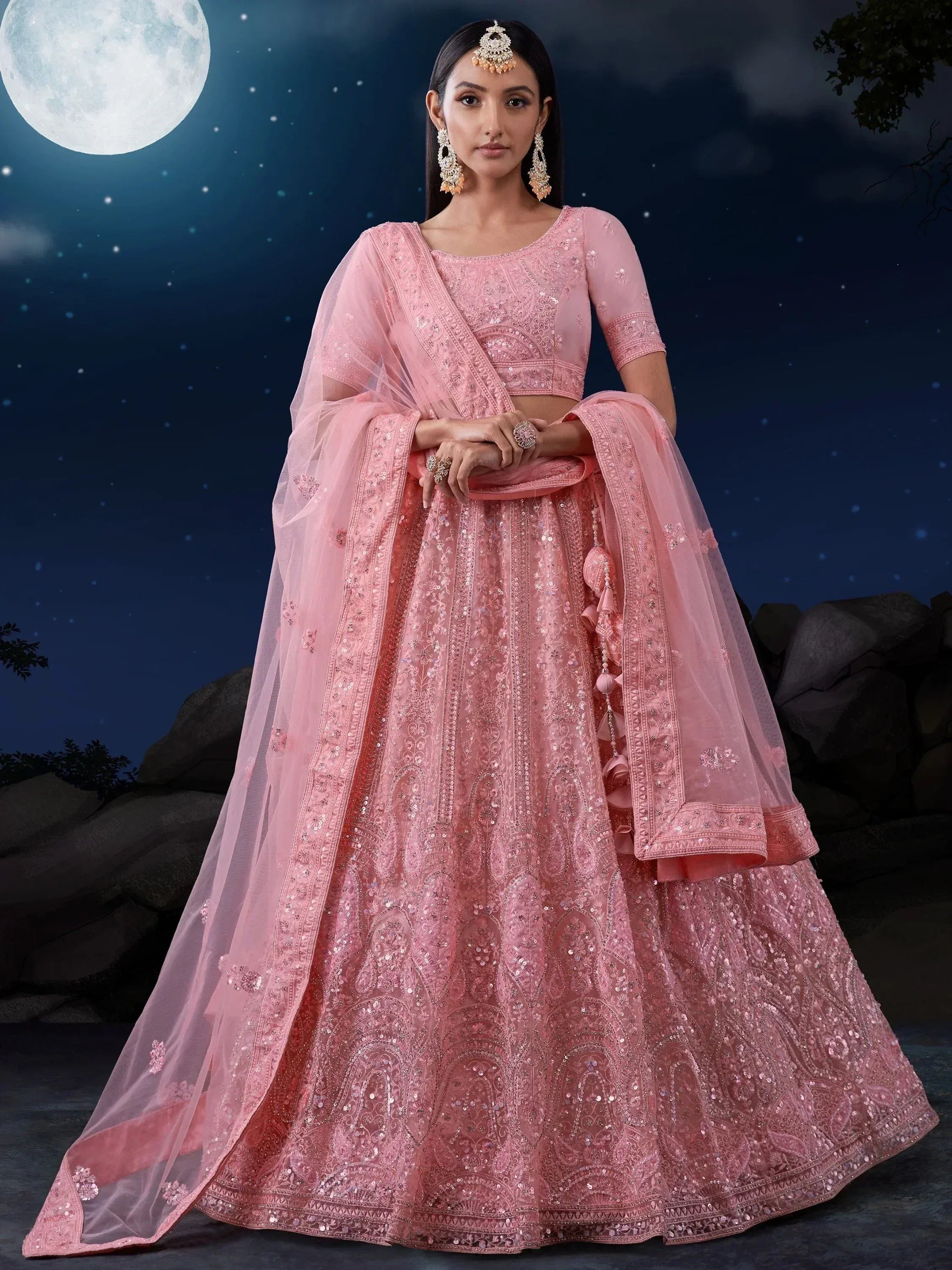 Pink embroidered lehenga choli with sequins, perfect for Indian weddings and festive occasions under moonlight.