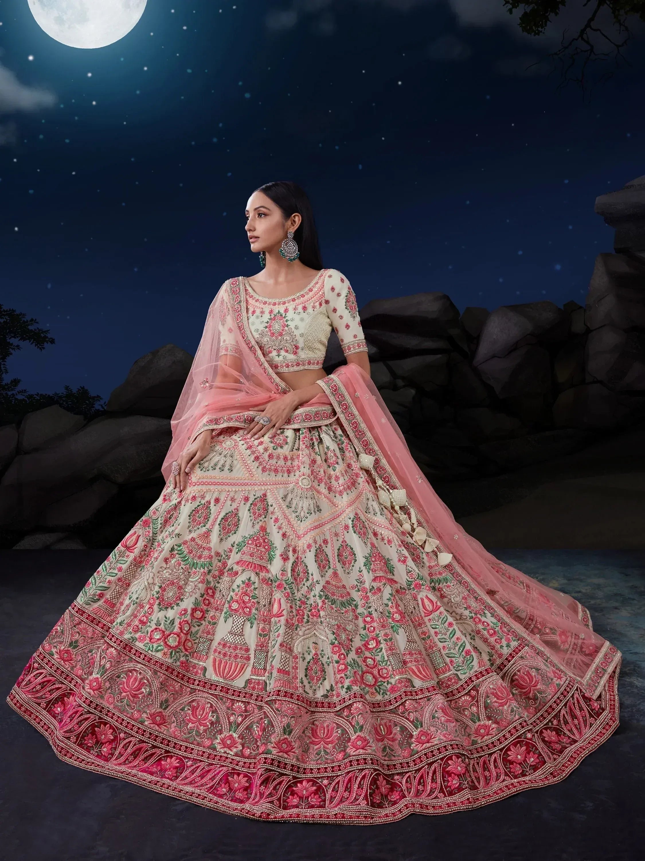 Elegant pink and cream embroidered lehenga choli under moonlight, perfect for Indian weddings and festive occasions.