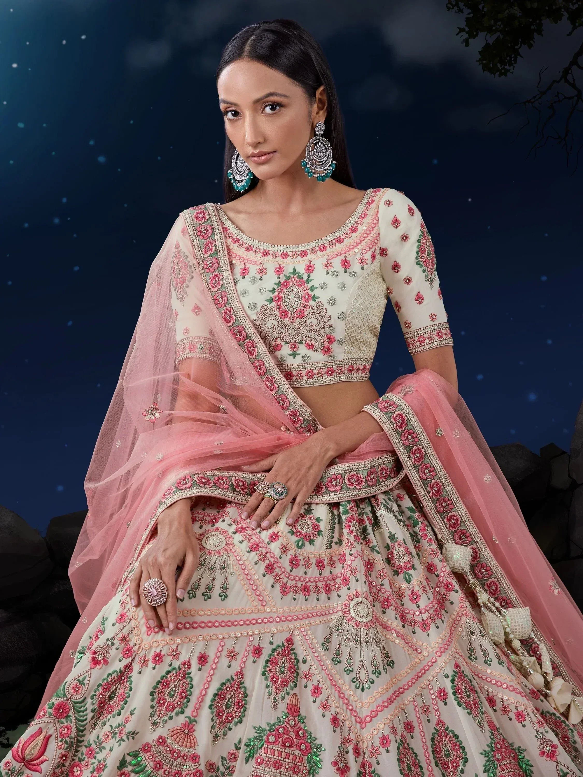 Elegant ivory and pink embroidered lehenga choli with floral motifs, perfect for Indian weddings and festive occasions.