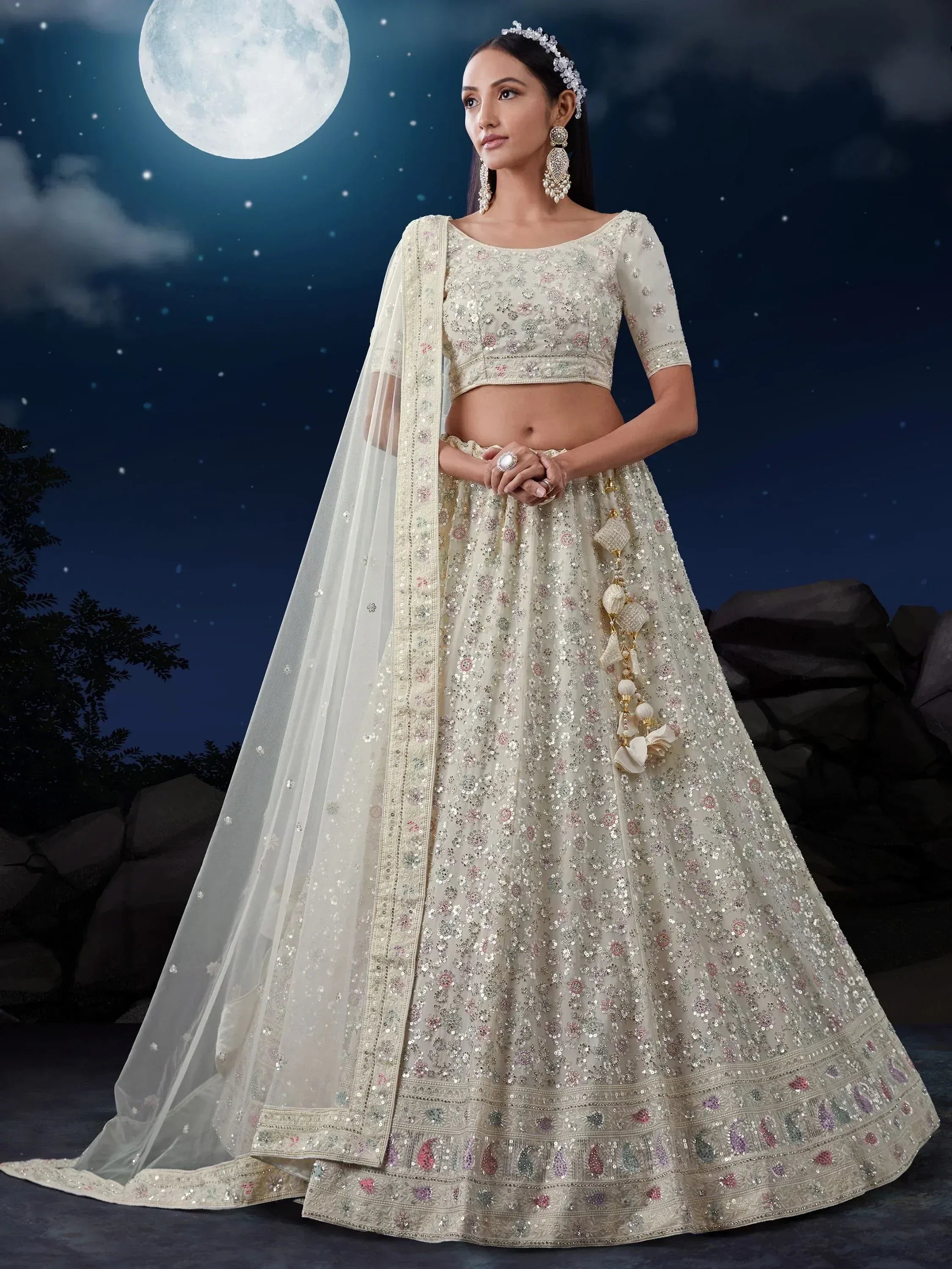 Elegant ivory lehenga choli with floral embroidery, sequins, and dupatta, perfect for Indian weddings under moonlight.