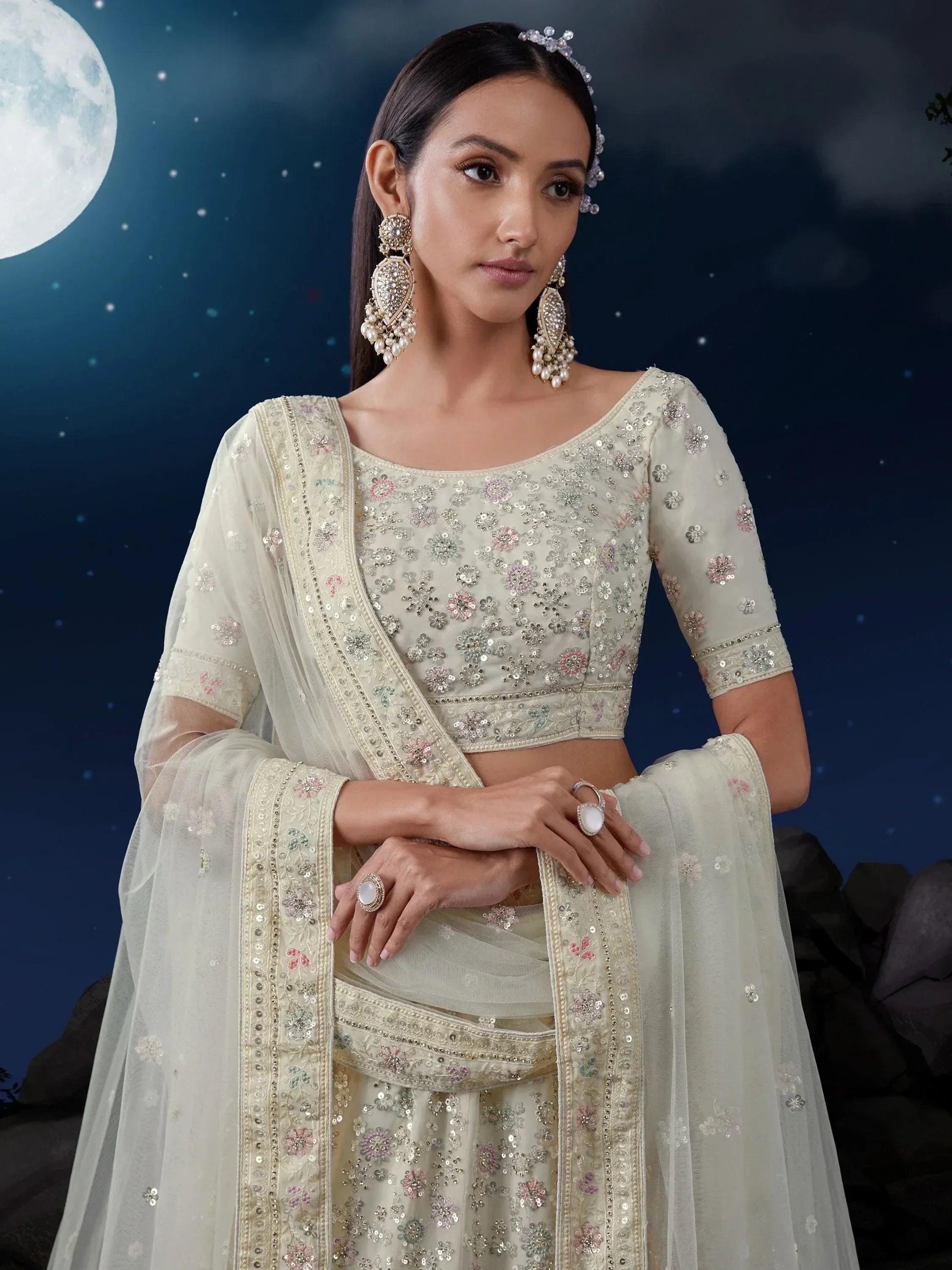 Elegant ivory lehenga choli with floral sequin embroidery, perfect for Indian ethnic wear events under moonlight.