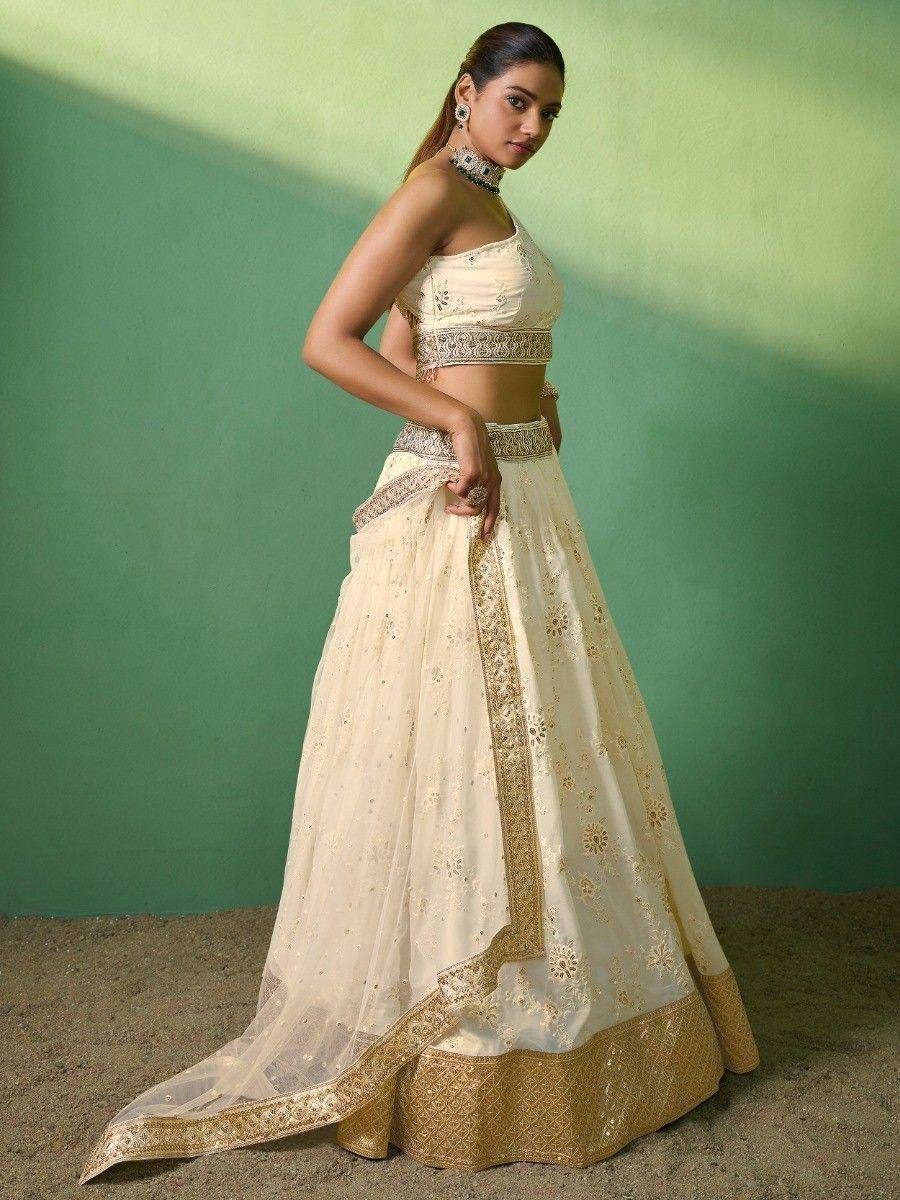 Cream and gold embroidered lehenga choli with floral motifs, perfect for Indian weddings and festive occasions.