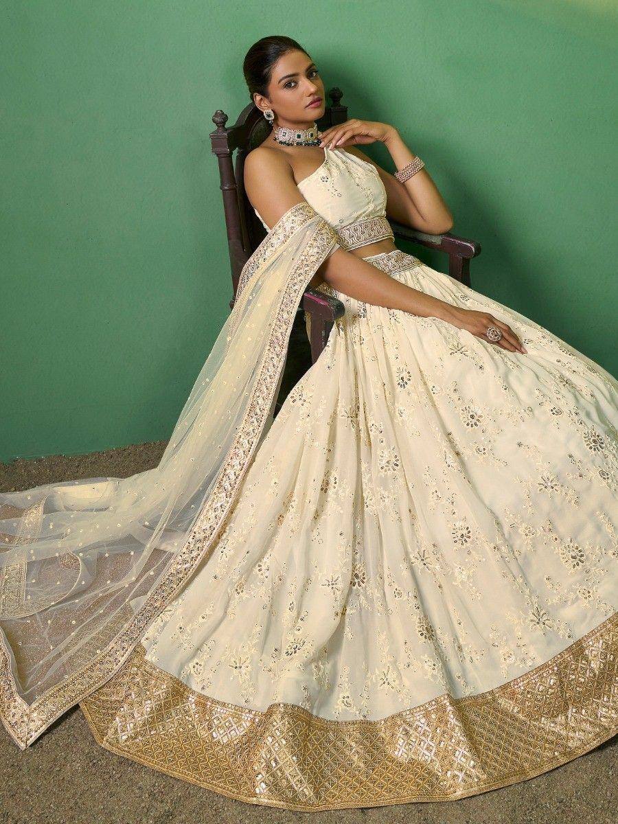 Cream designer lehenga choli with gold embroidery, perfect for Indian weddings and festive occasions.