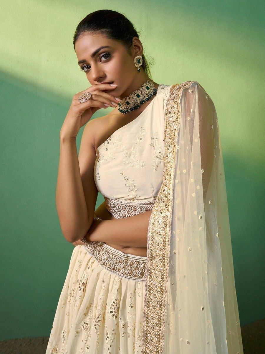 Cream embroidered lehenga choli with gold detailing and sheer dupatta, perfect for Indian ethnic occasions