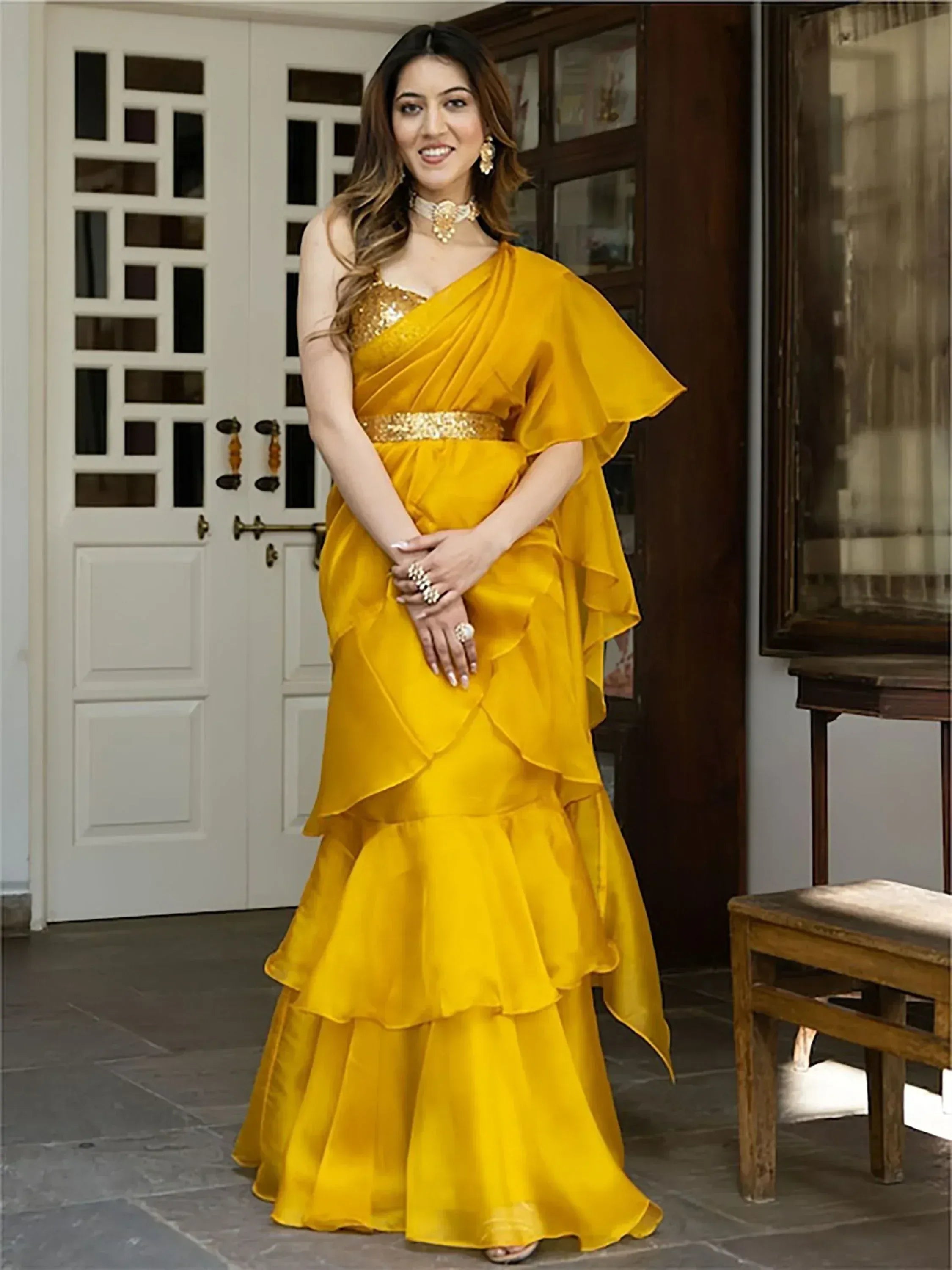 Yellow ethnic gown with ruffled layers and gold embellishments, perfect for Indian festive occasions