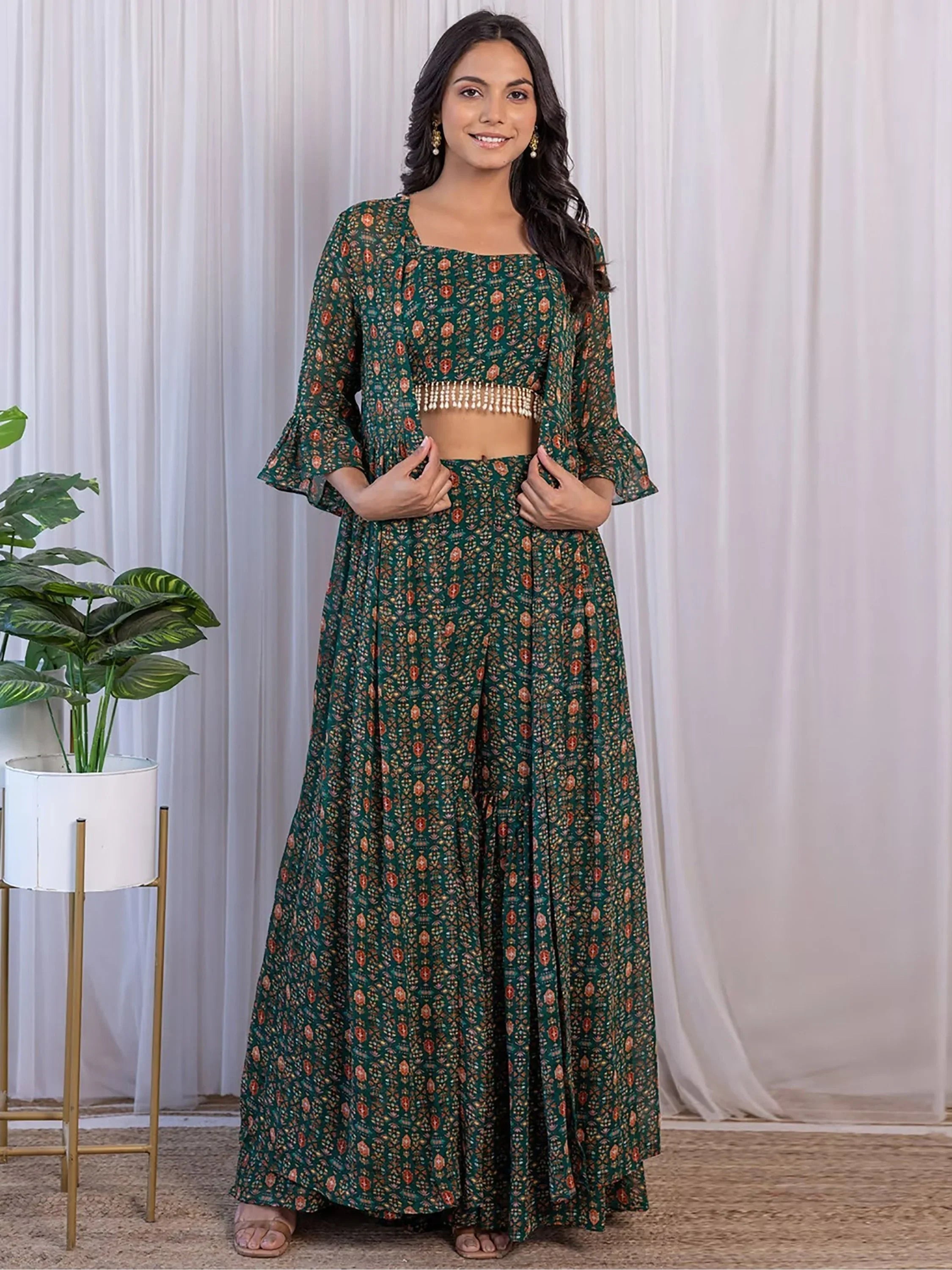 Woman wearing green printed ethnic lehenga choli set with flared sleeves, indoor setting