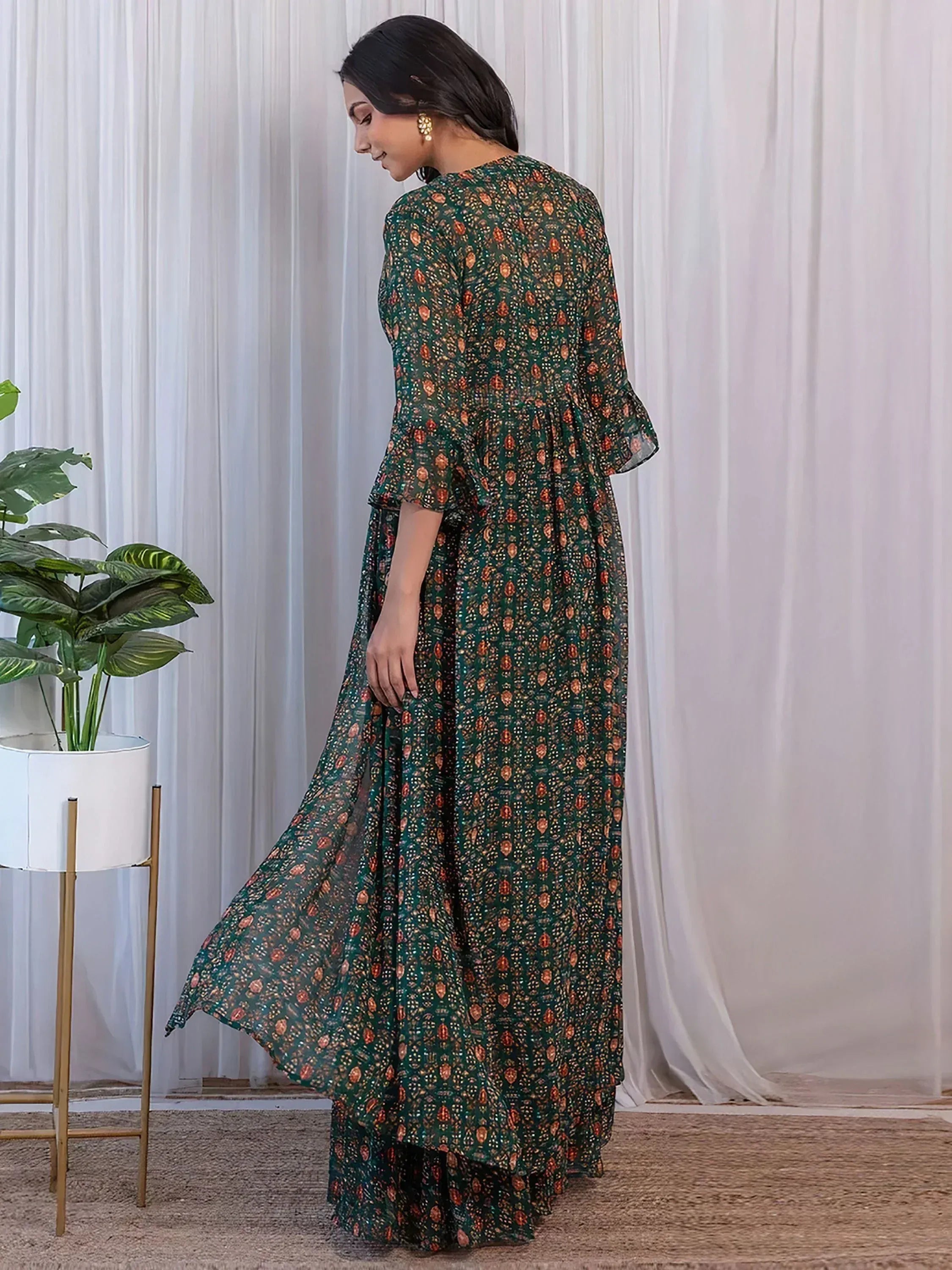 Woman in green printed ethnic gown with flared sleeves, perfect for Indian occasions
