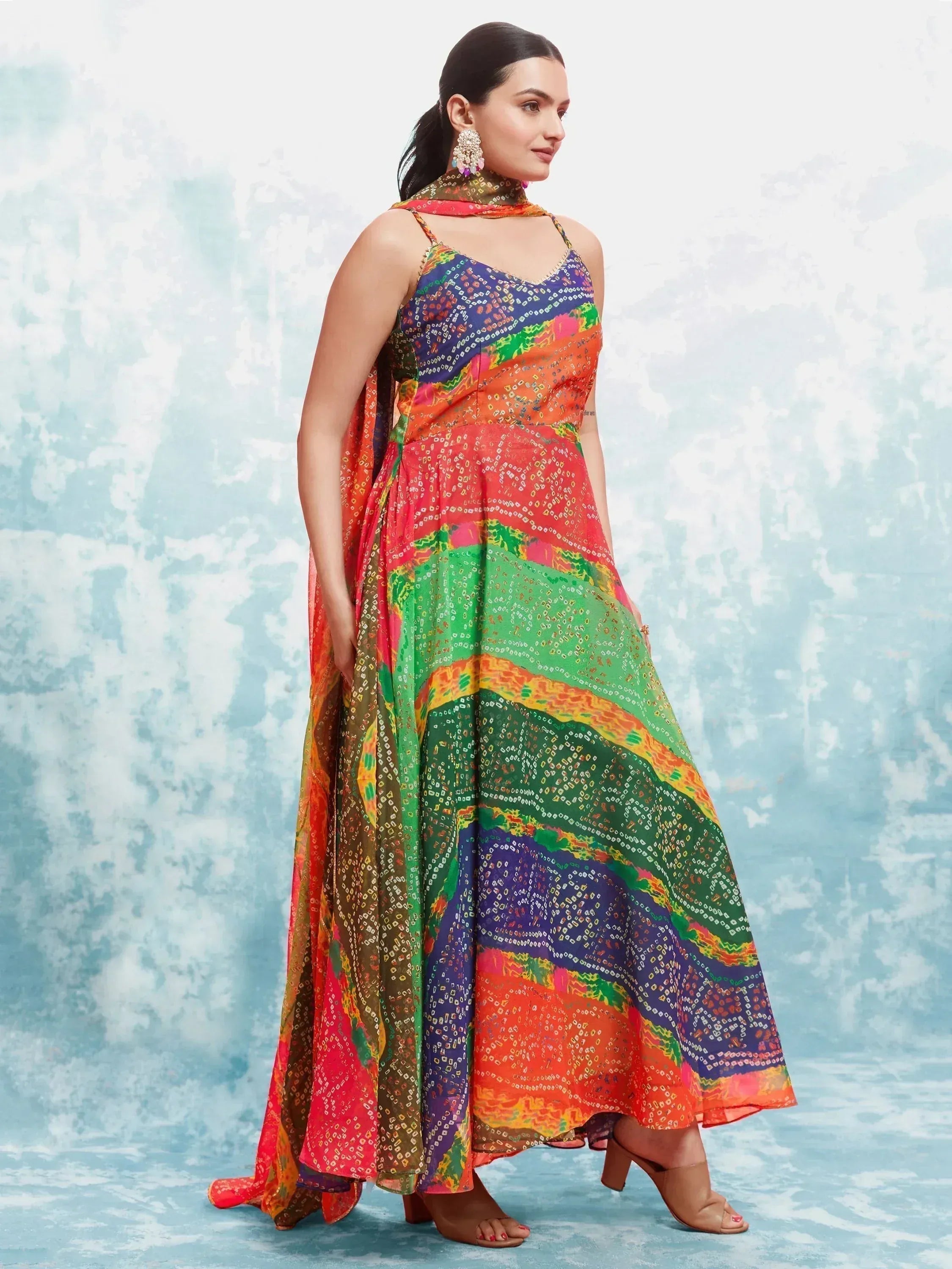 Woman wearing colorful bandhani print ethnic gown with dupatta and statement earrings