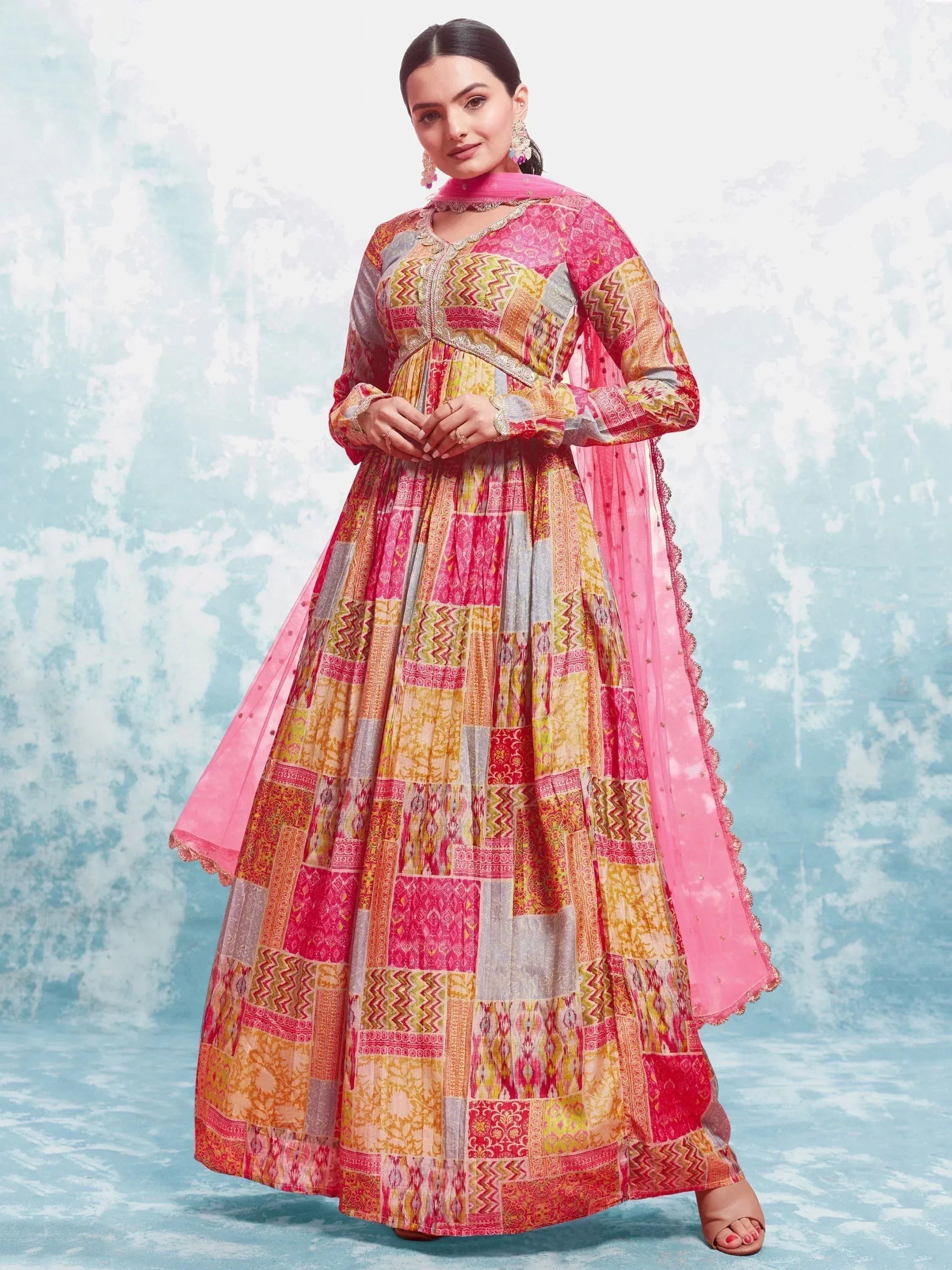 Woman in colorful printed Anarkali suit with long sleeves and pink dupatta, Indian ethnic wear
