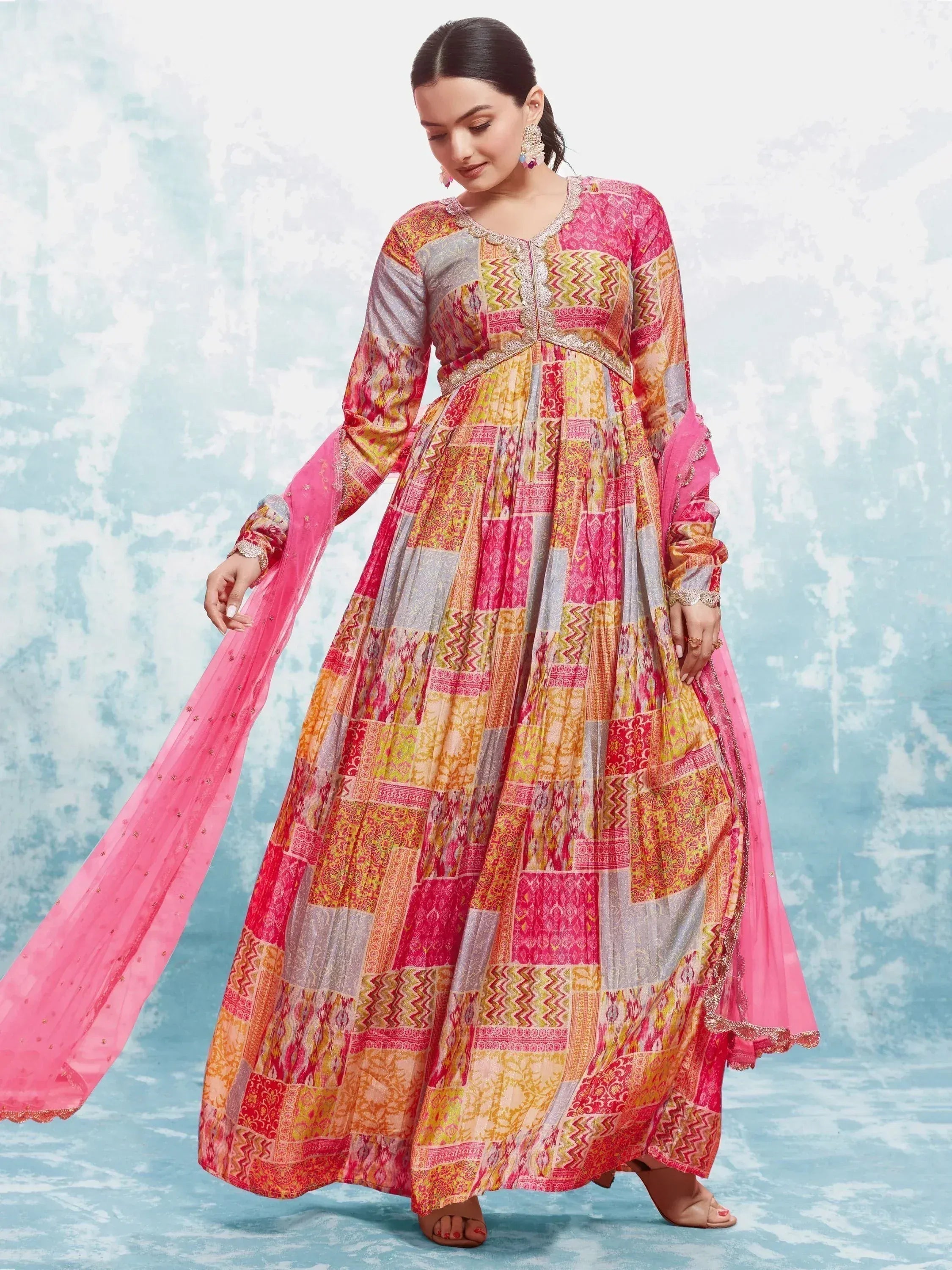 Woman wearing vibrant multi-color ethnic gown with patchwork print and pink dupatta