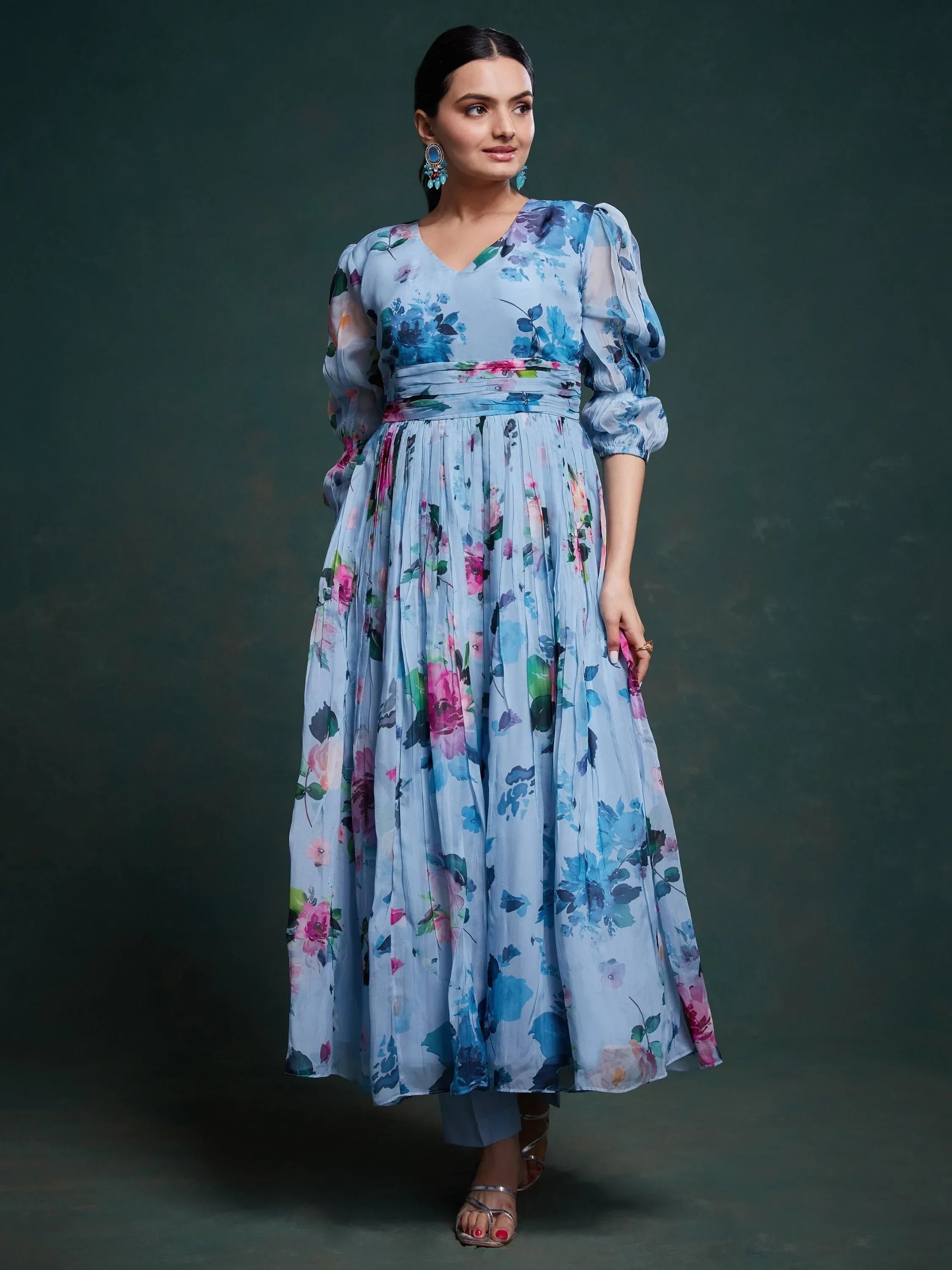 Woman in a blue floral printed ethnic gown with puff sleeves and pleated skirt