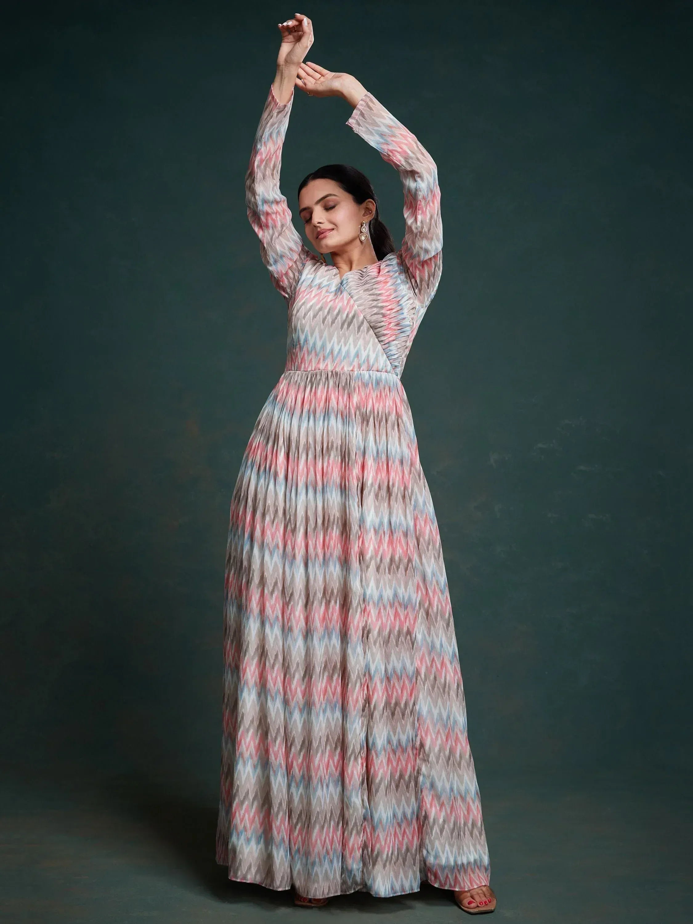 Woman wearing a long ethnic gown with pastel zigzag print and long sleeves