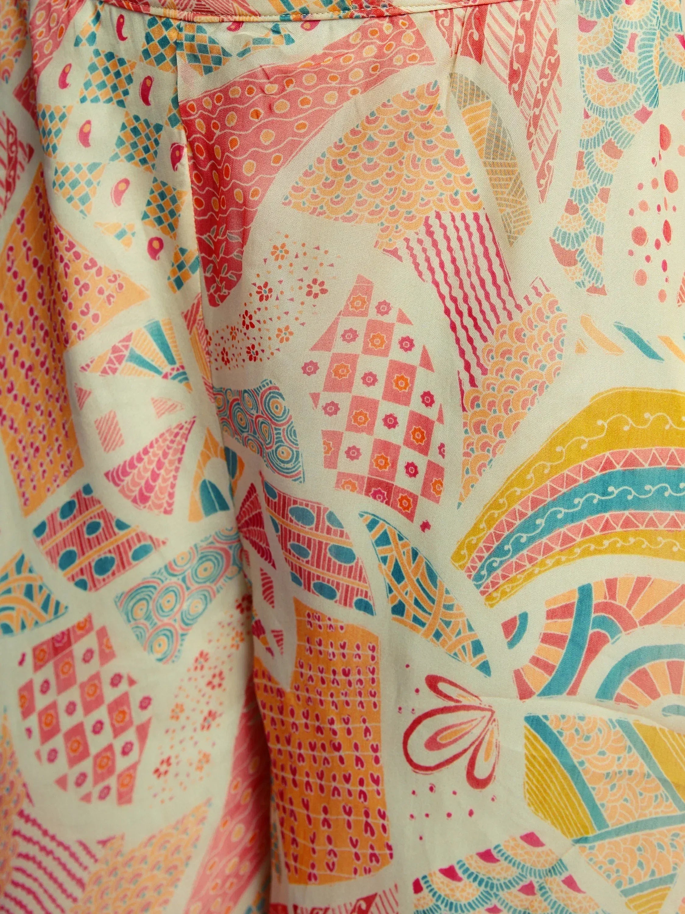 Close-up of colorful geometric and abstract print on ethnic fabric, pastel pink yellow blue