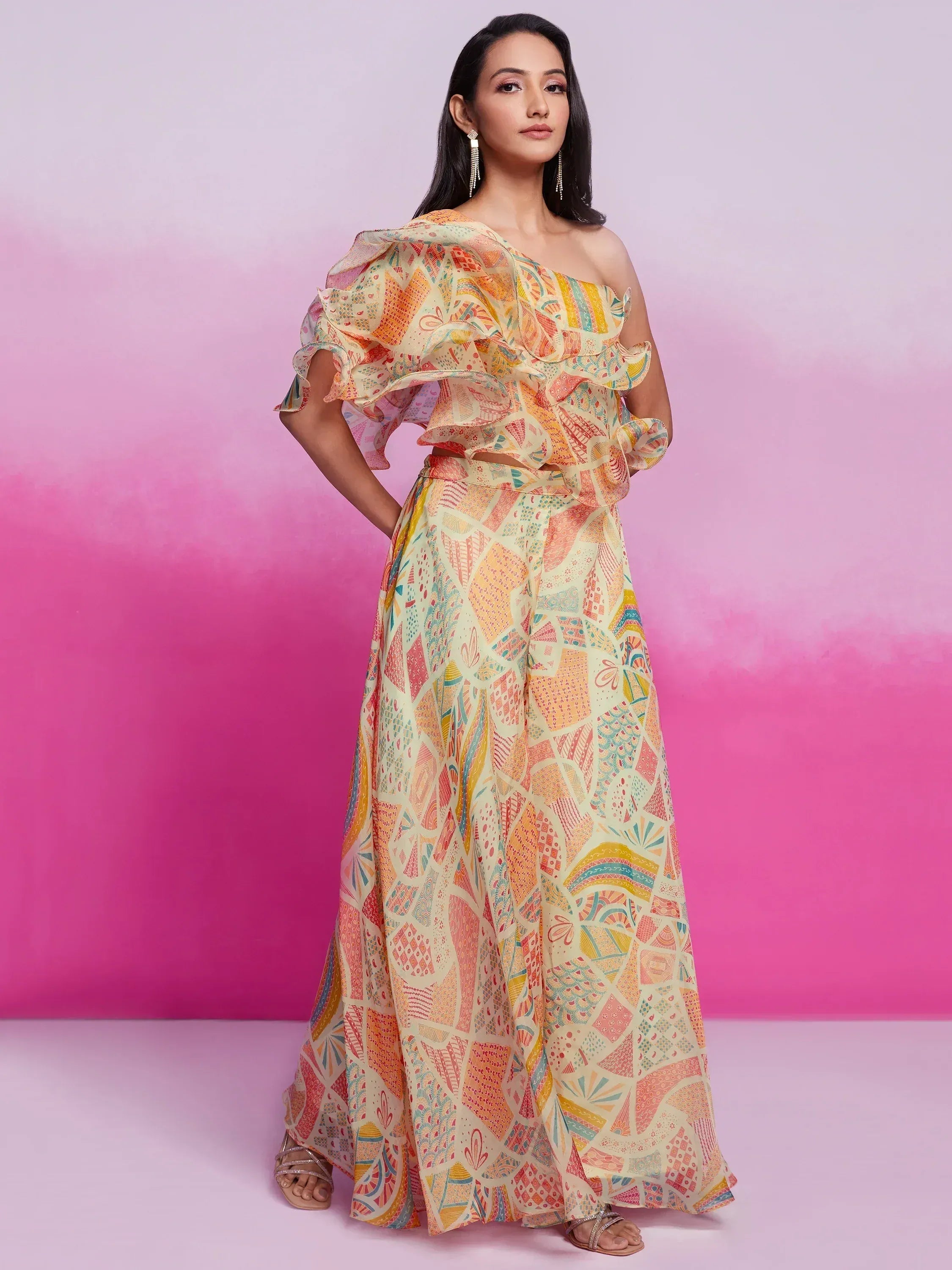 Woman wearing a one shoulder pastel ethnic gown with abstract print and ruffle detailing