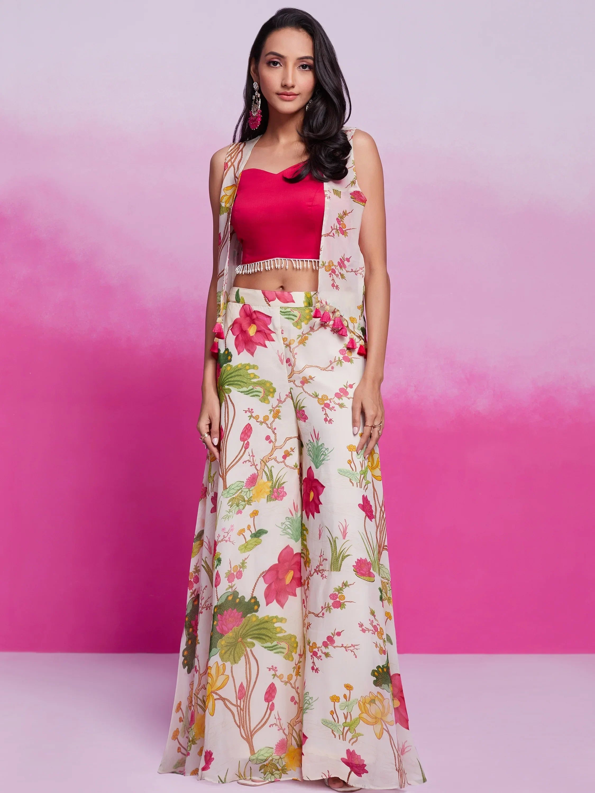 Woman wearing a pink crop top with floral printed palazzo pants and matching jacket