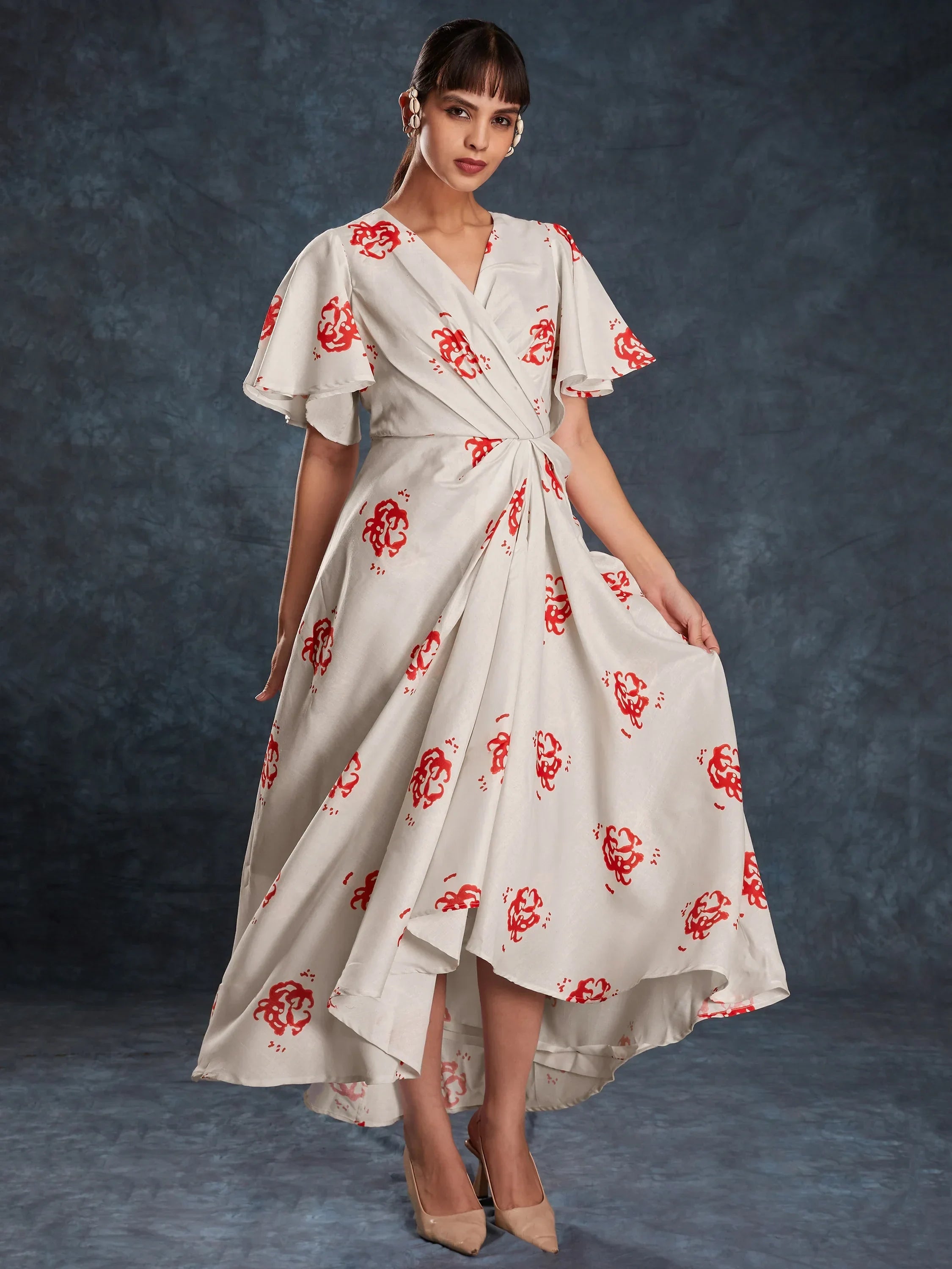 Woman in elegant white floral print ethnic gown with flared sleeves, asymmetric hem