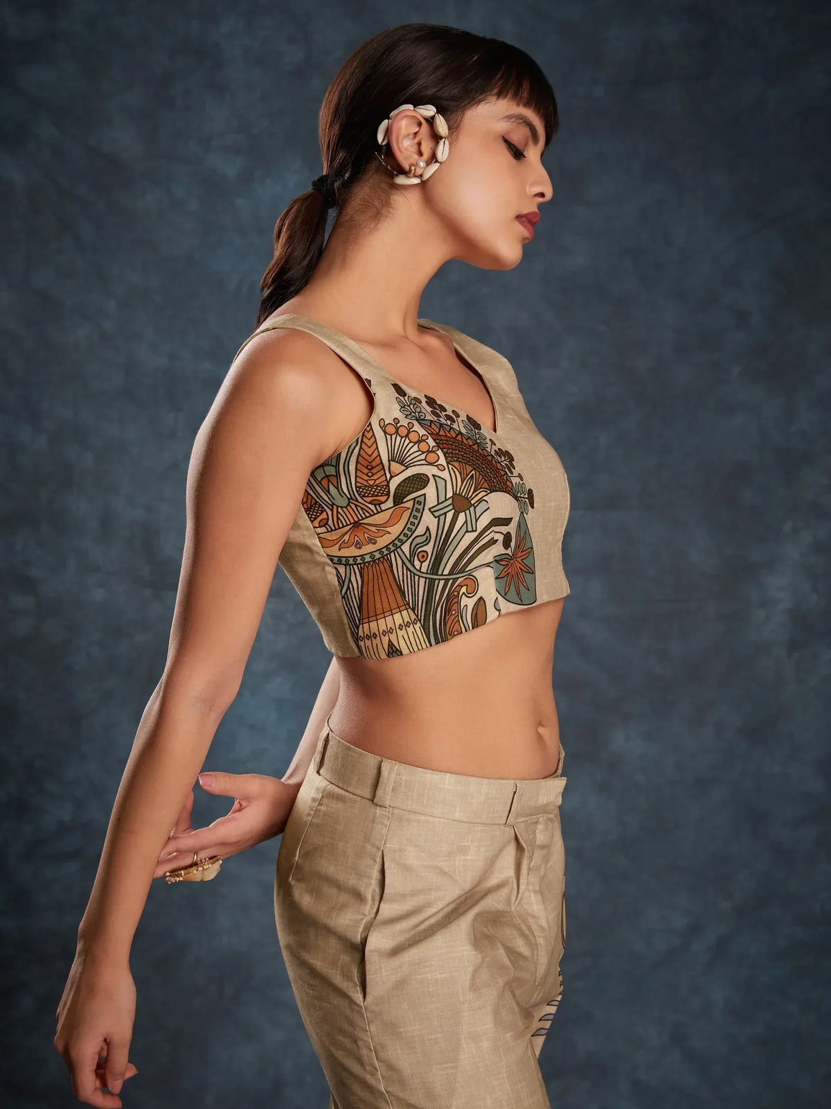 Woman in ethnic printed crop top and matching pants, showcasing designer Indian wear with shell hair accessory