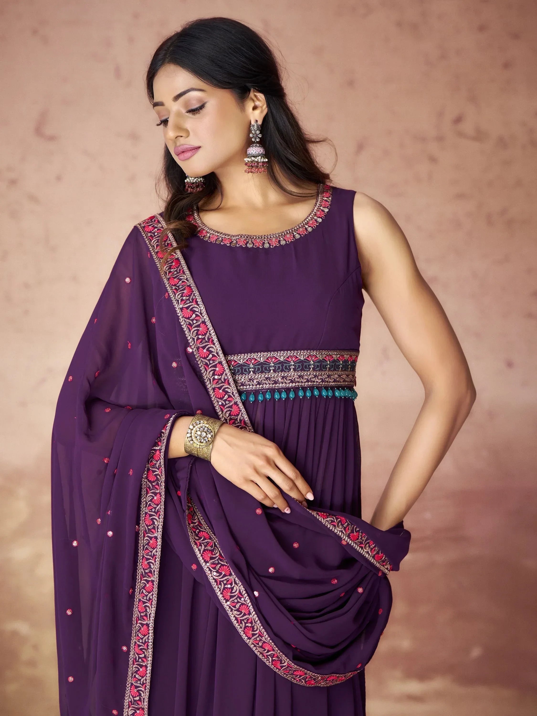 Woman in purple embroidered anarkali suit with matching dupatta and traditional jewelry