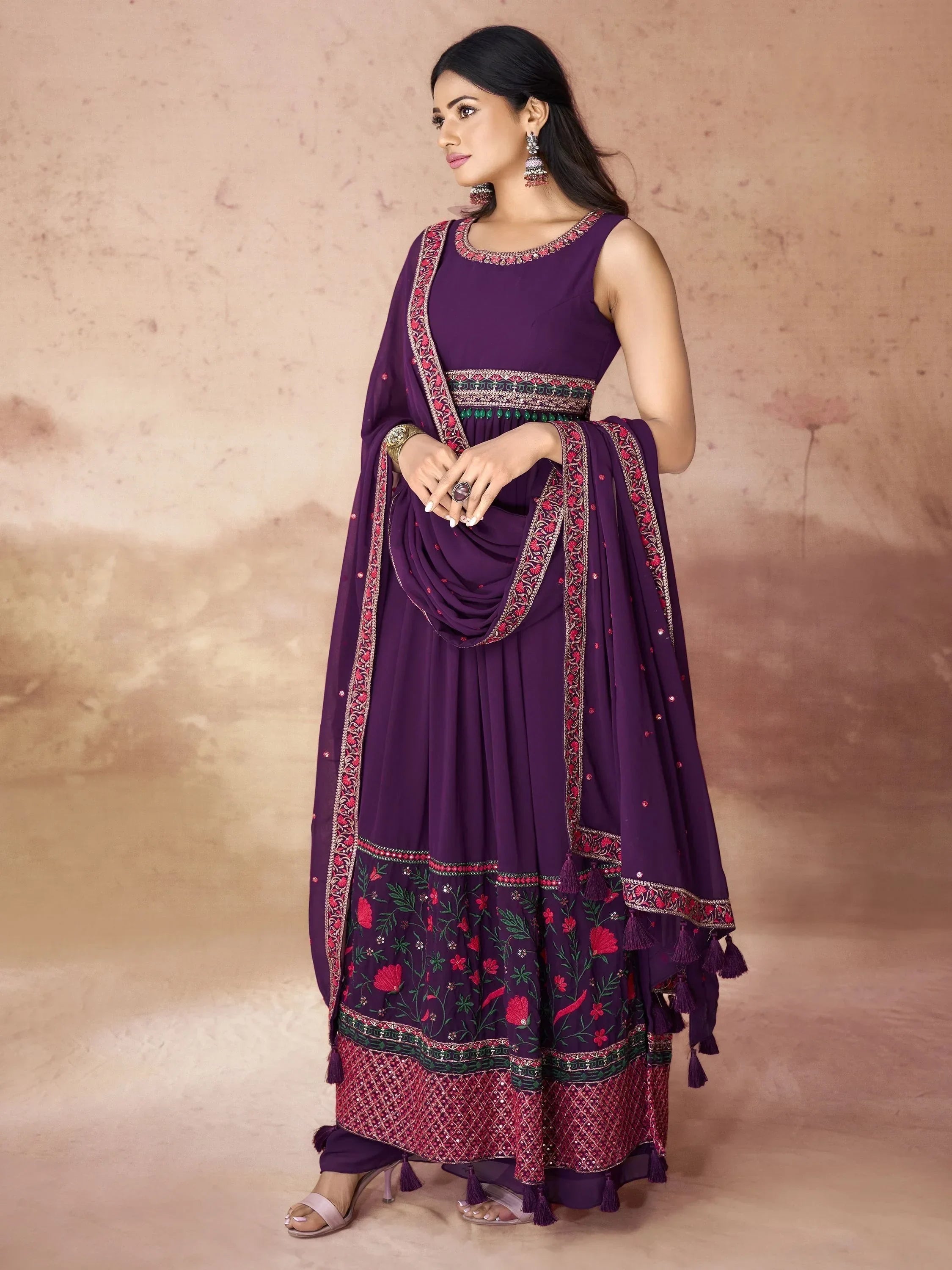 Woman wearing a purple embroidered ethnic gown with floral designs and matching dupatta