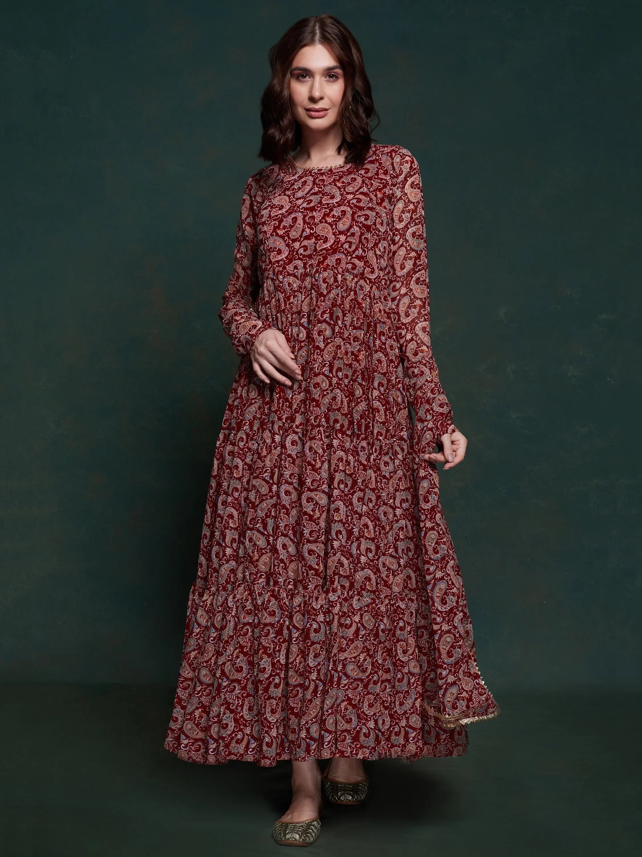 Woman wearing maroon paisley printed ethnic gown with long sleeves and round neckline