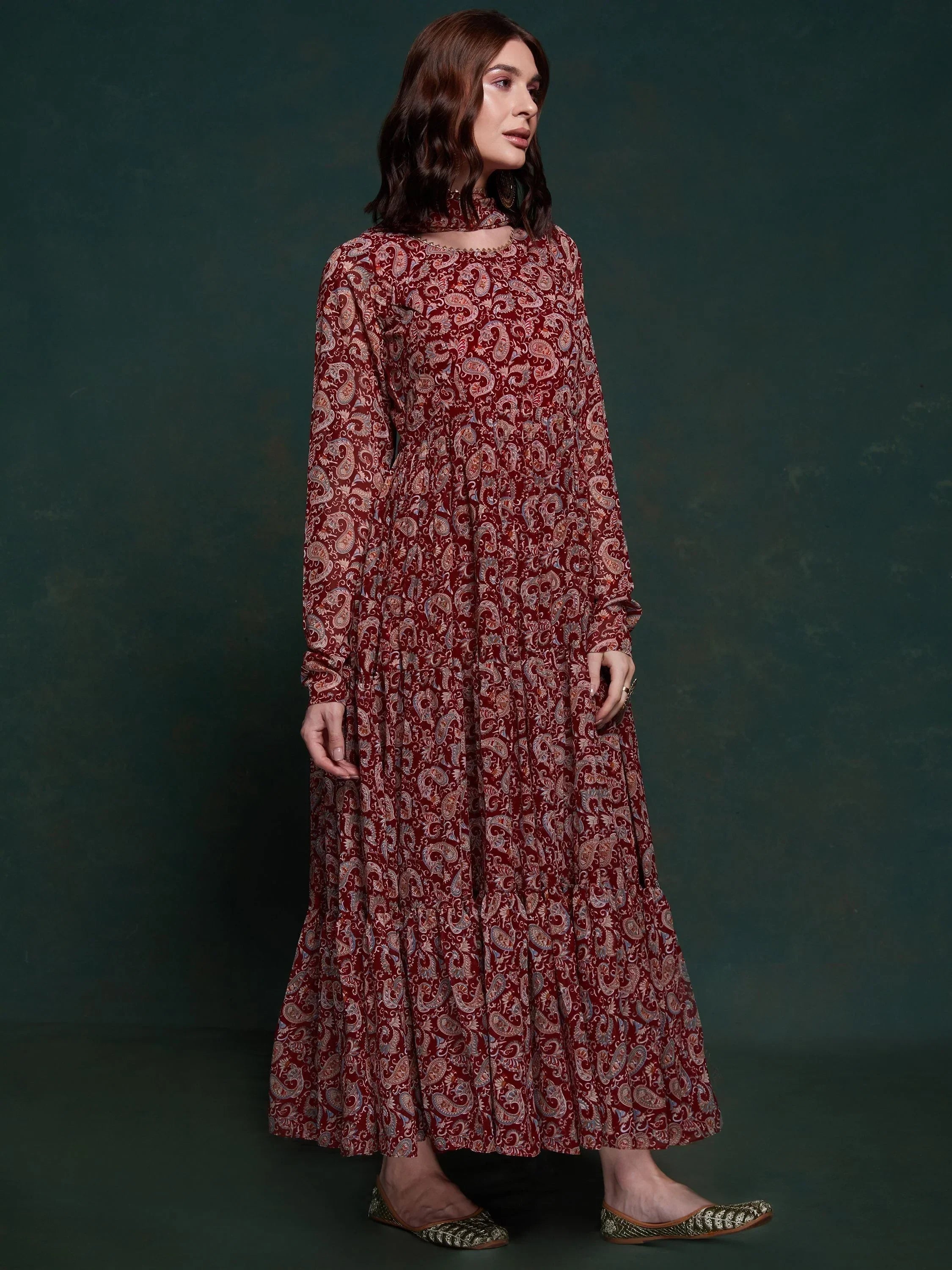 Woman wearing a maroon paisley print ethnic gown with long sleeves and matching scarf