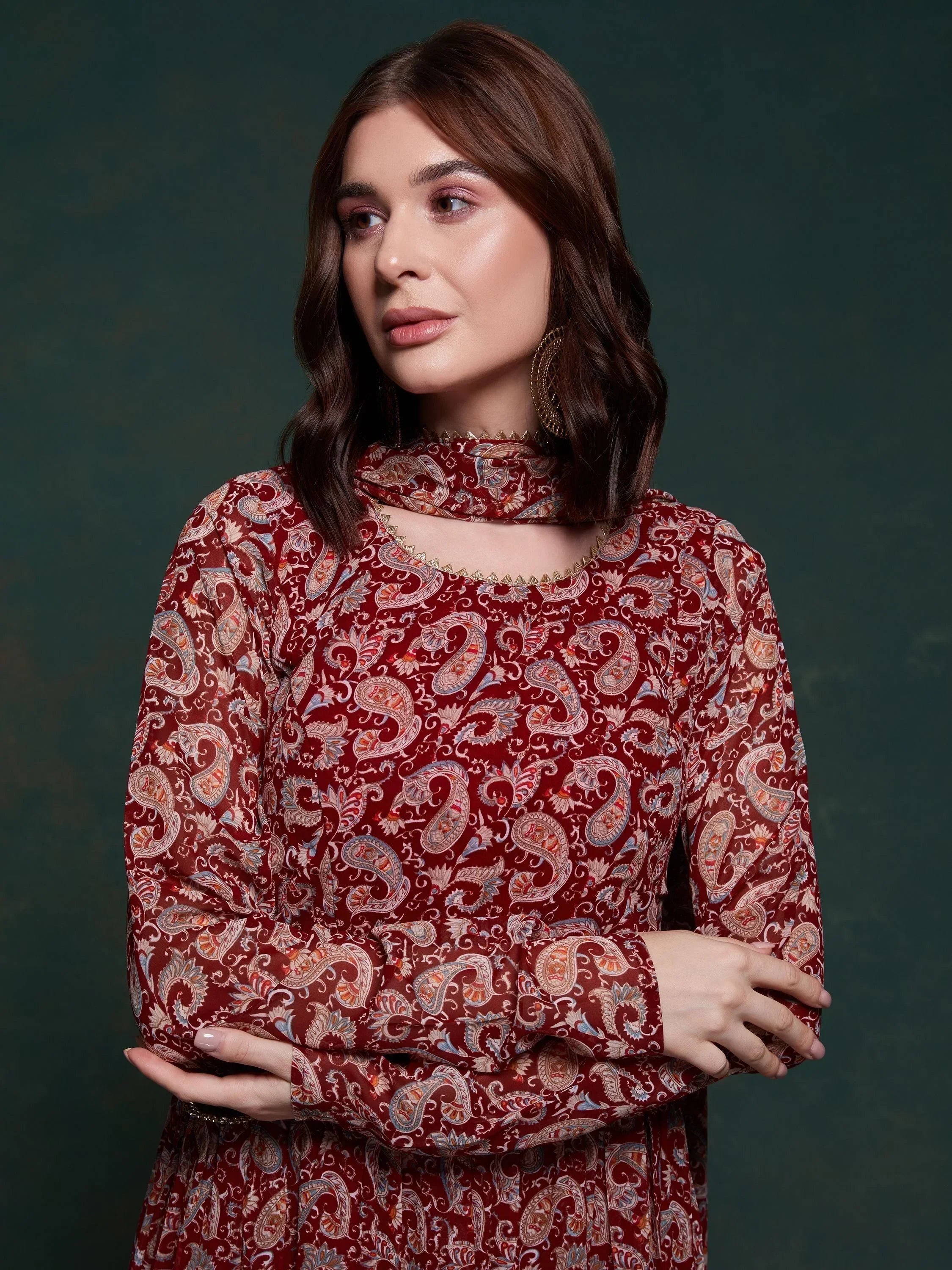 Woman wearing a maroon paisley print ethnic dress with high neck and long sleeves