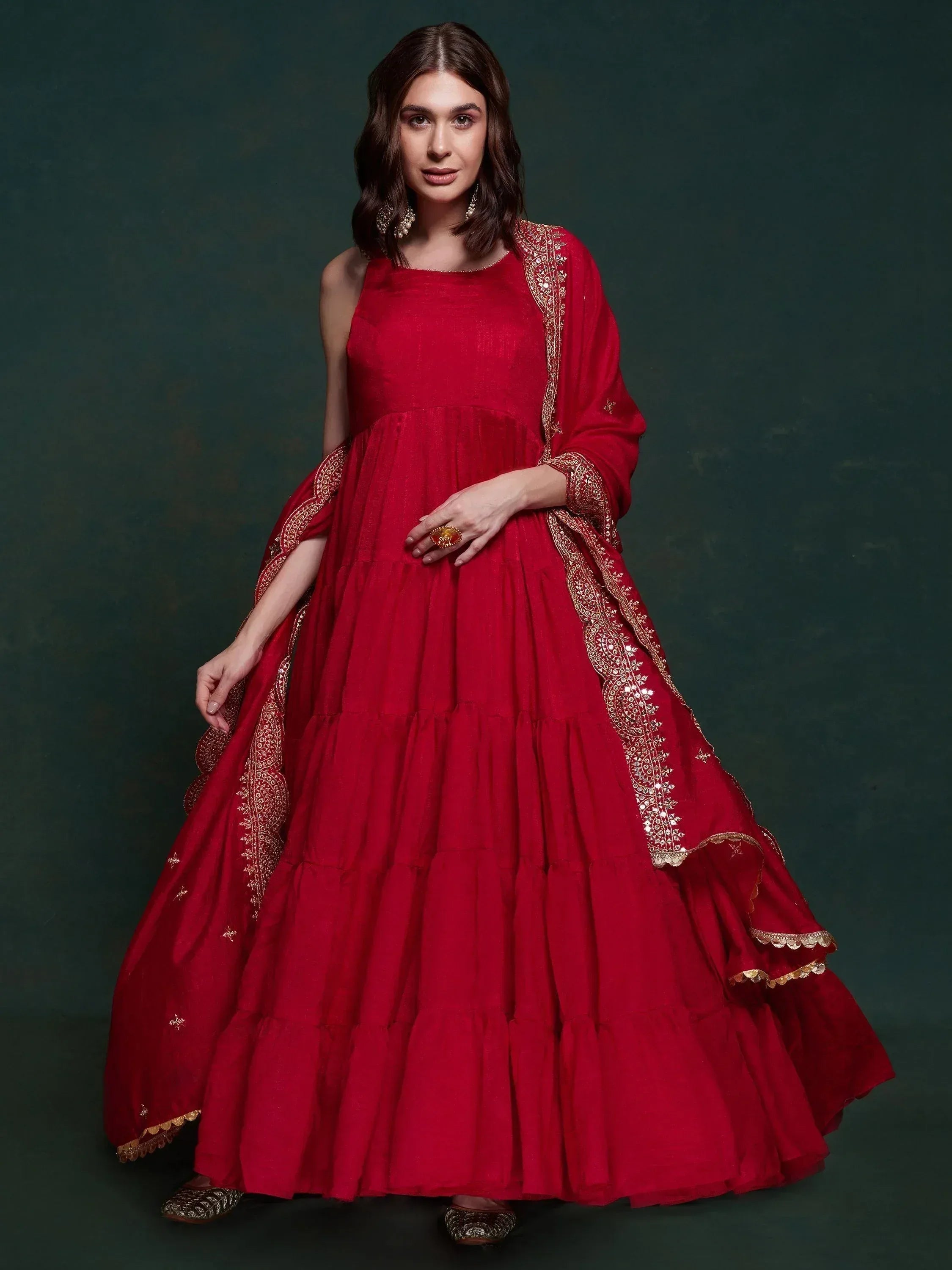 Red ethnic gown with gold embroidery and tiered skirt, perfect for Indian weddings and festive occasions