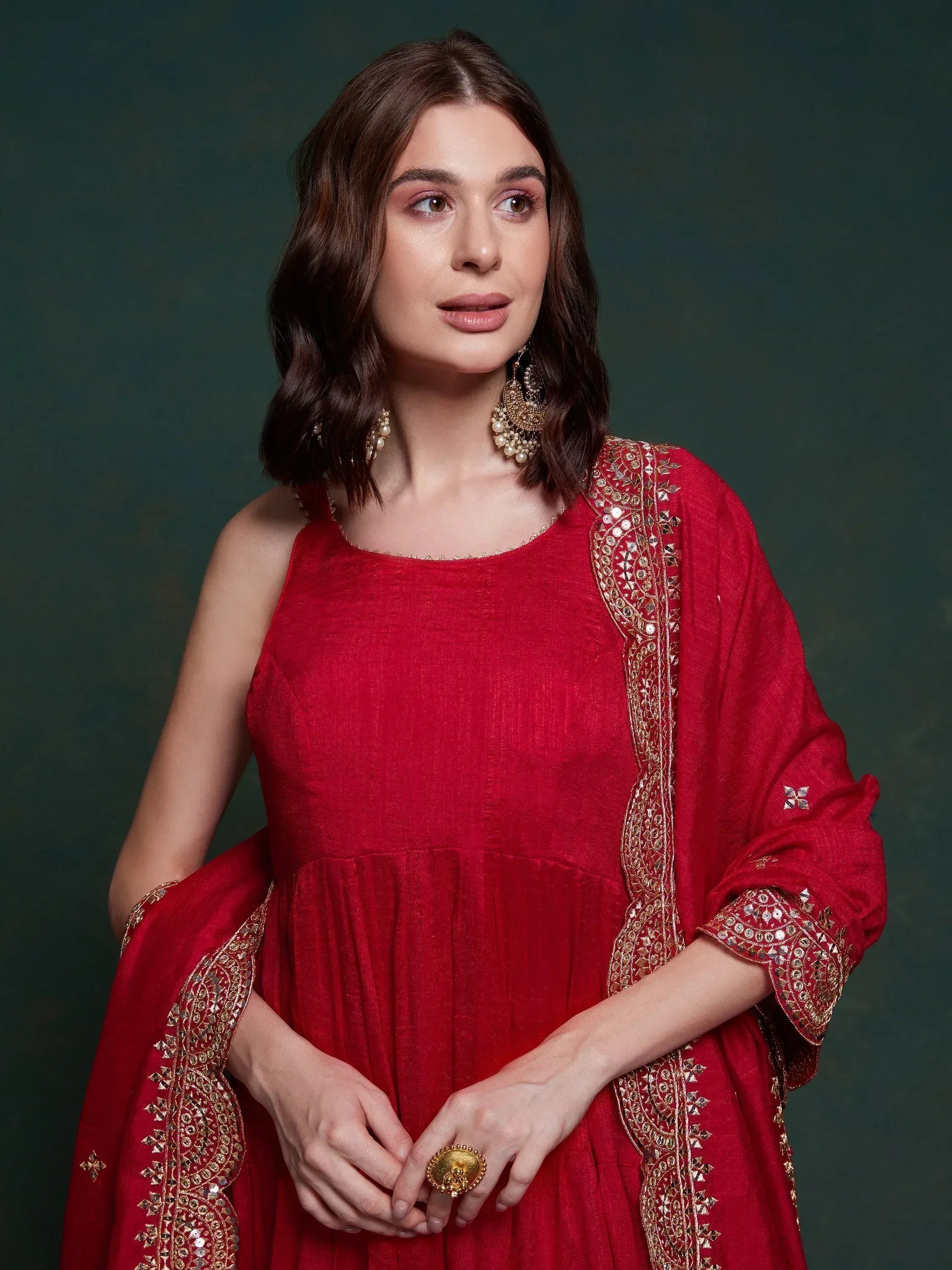 Red ethnic gown with gold mirror work, perfect for Indian weddings and festive occasions.