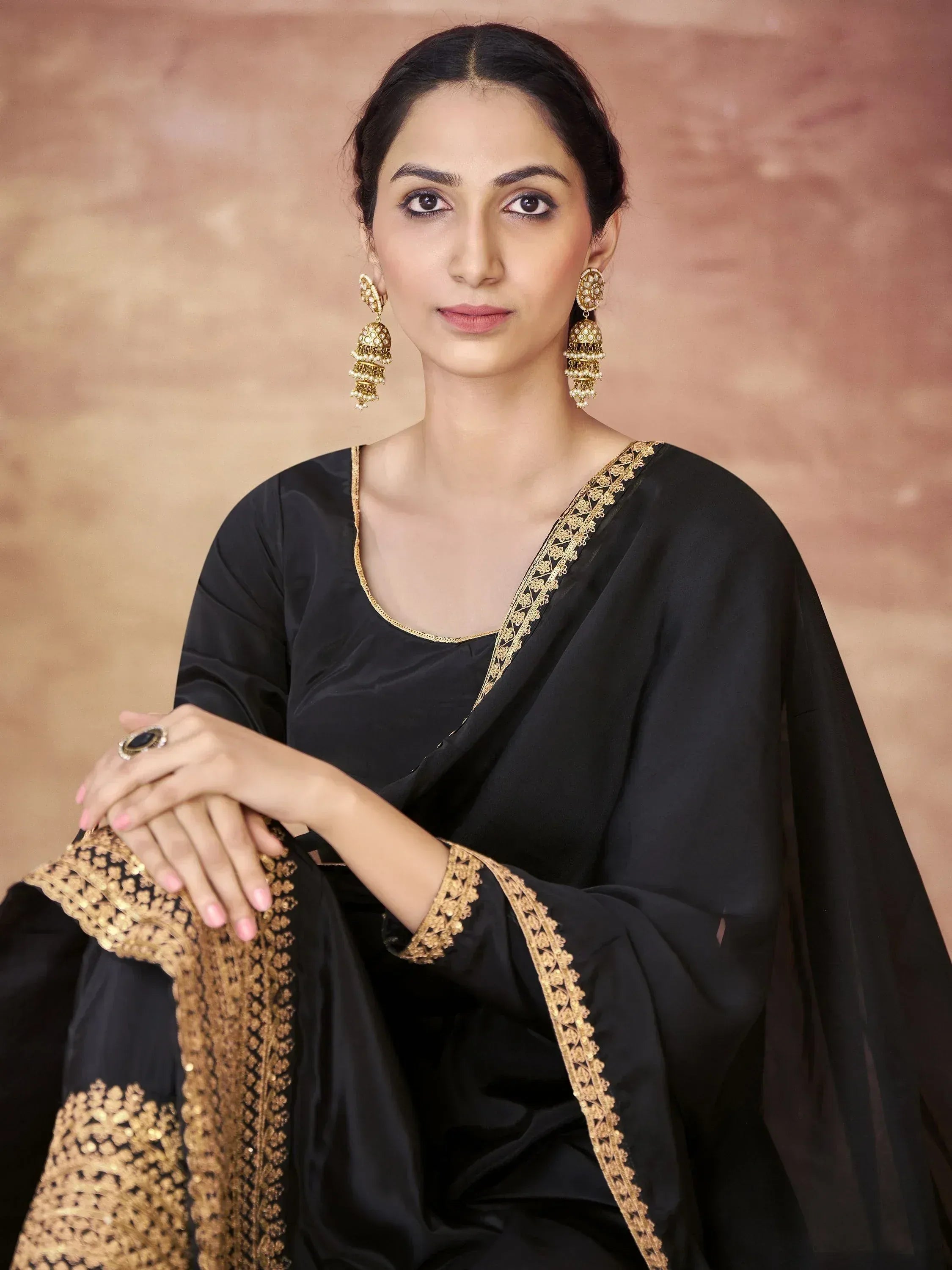 Black ethnic saree with gold embroidery and jhumka earrings for Indian festive wear