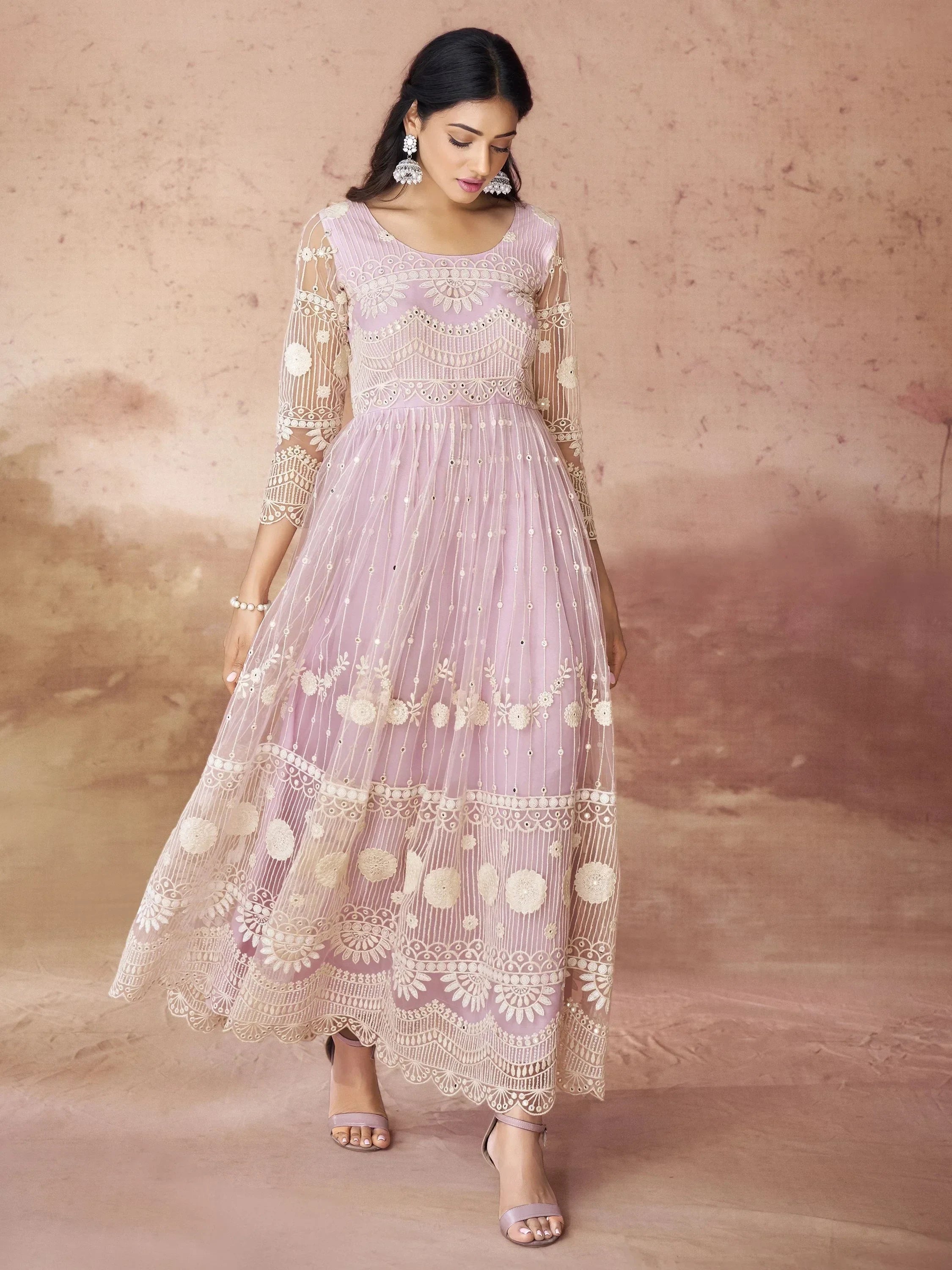 Woman wearing pastel lavender net embroidered ethnic gown with intricate floral designs