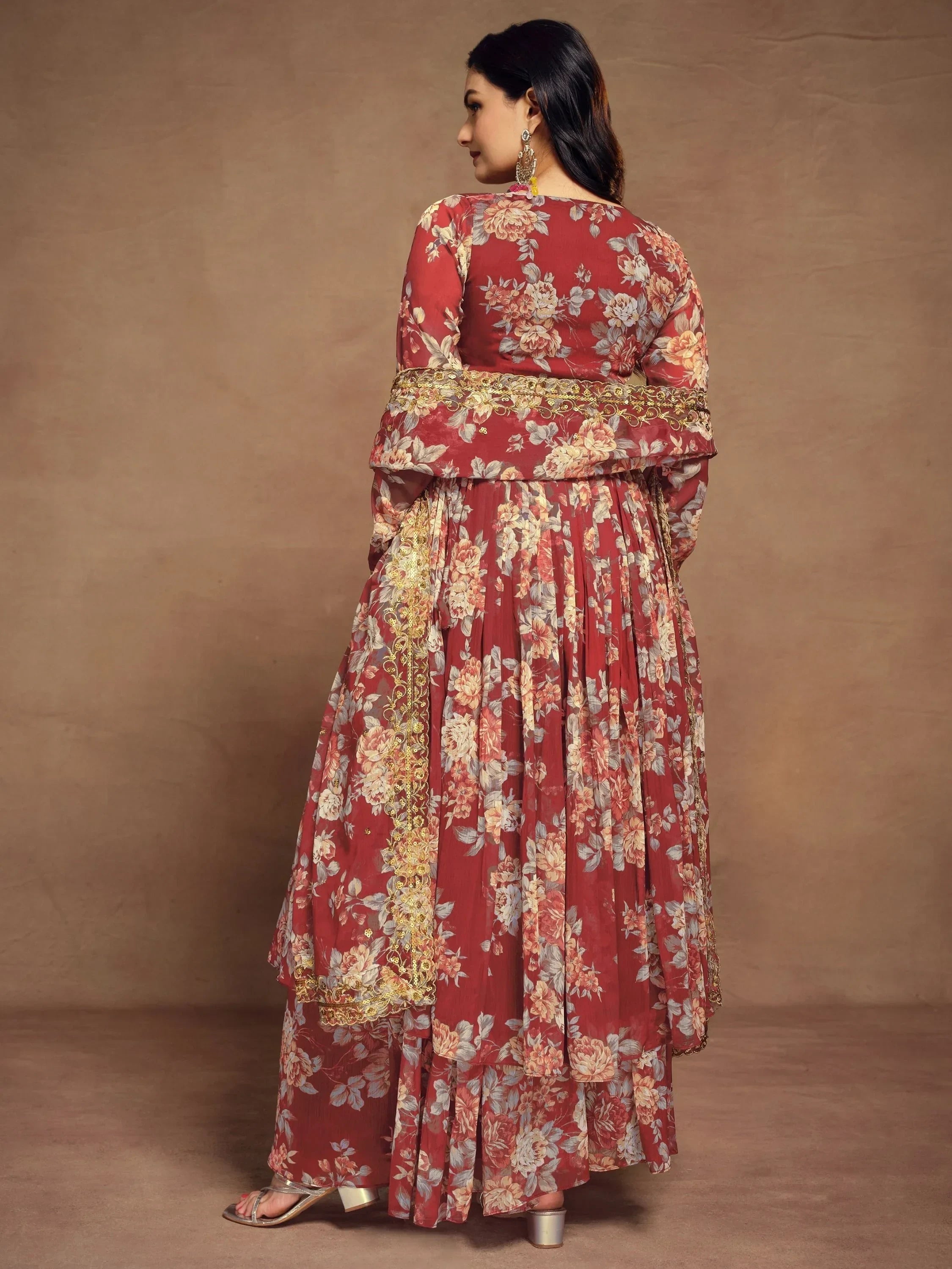 Woman wearing maroon floral printed ethnic gown with long sleeves and gold embroidery