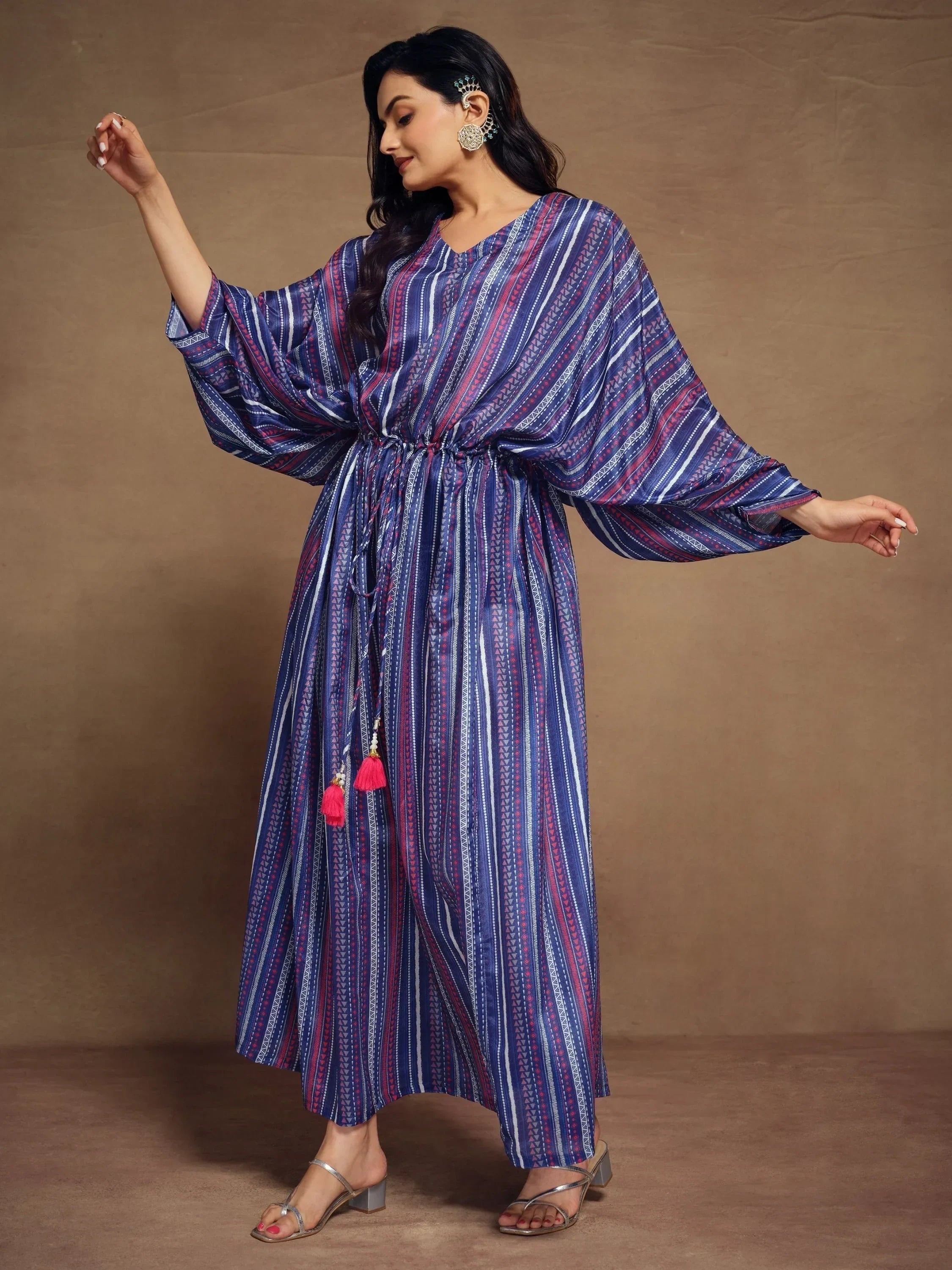 Woman wearing blue and purple striped kaftan dress with waist tie and tassels, ethnic outfit