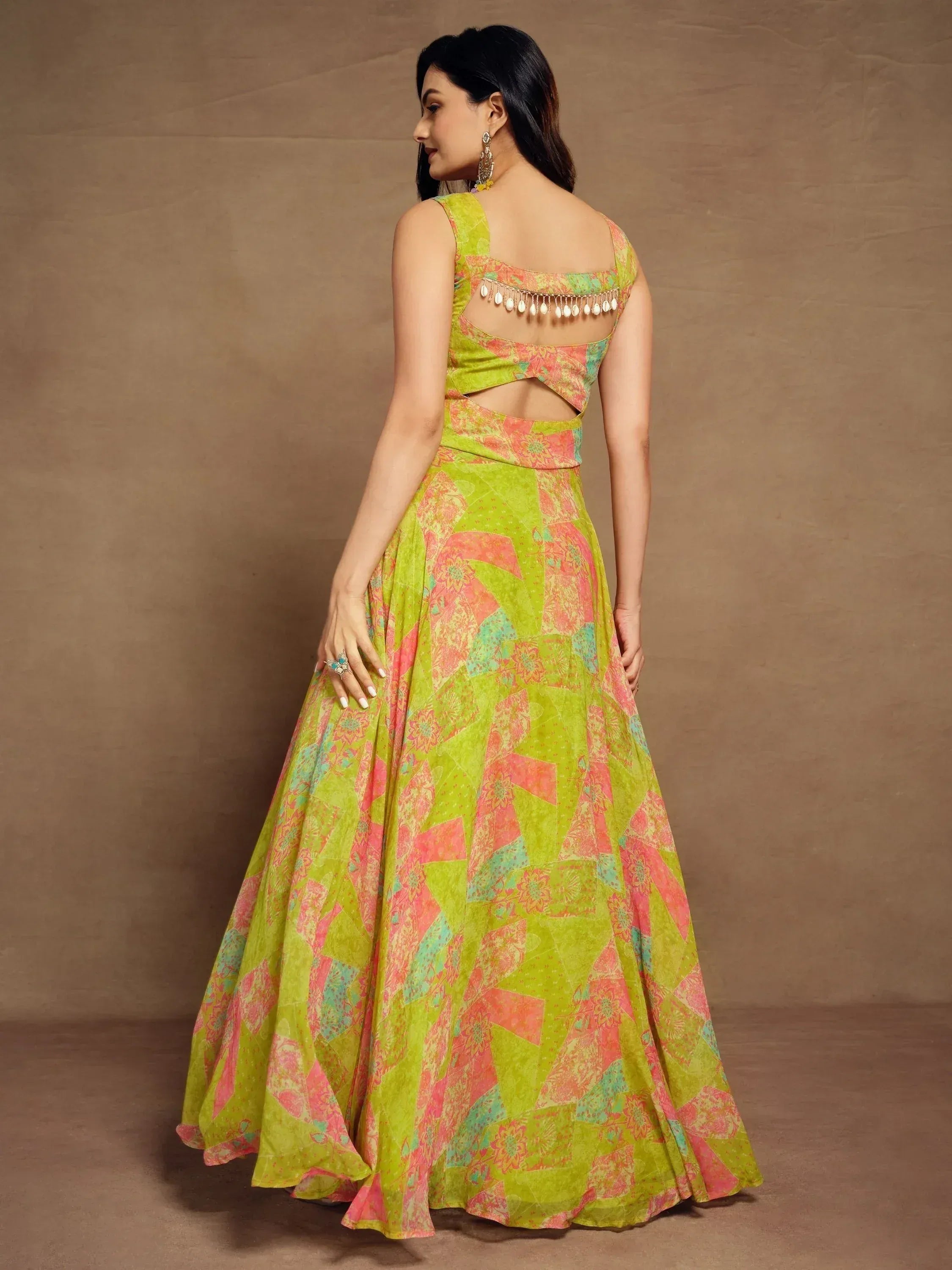 Vibrant green and pink printed lehenga choli with back cutout and tassel detailing, perfect for Indian ethnic wear.