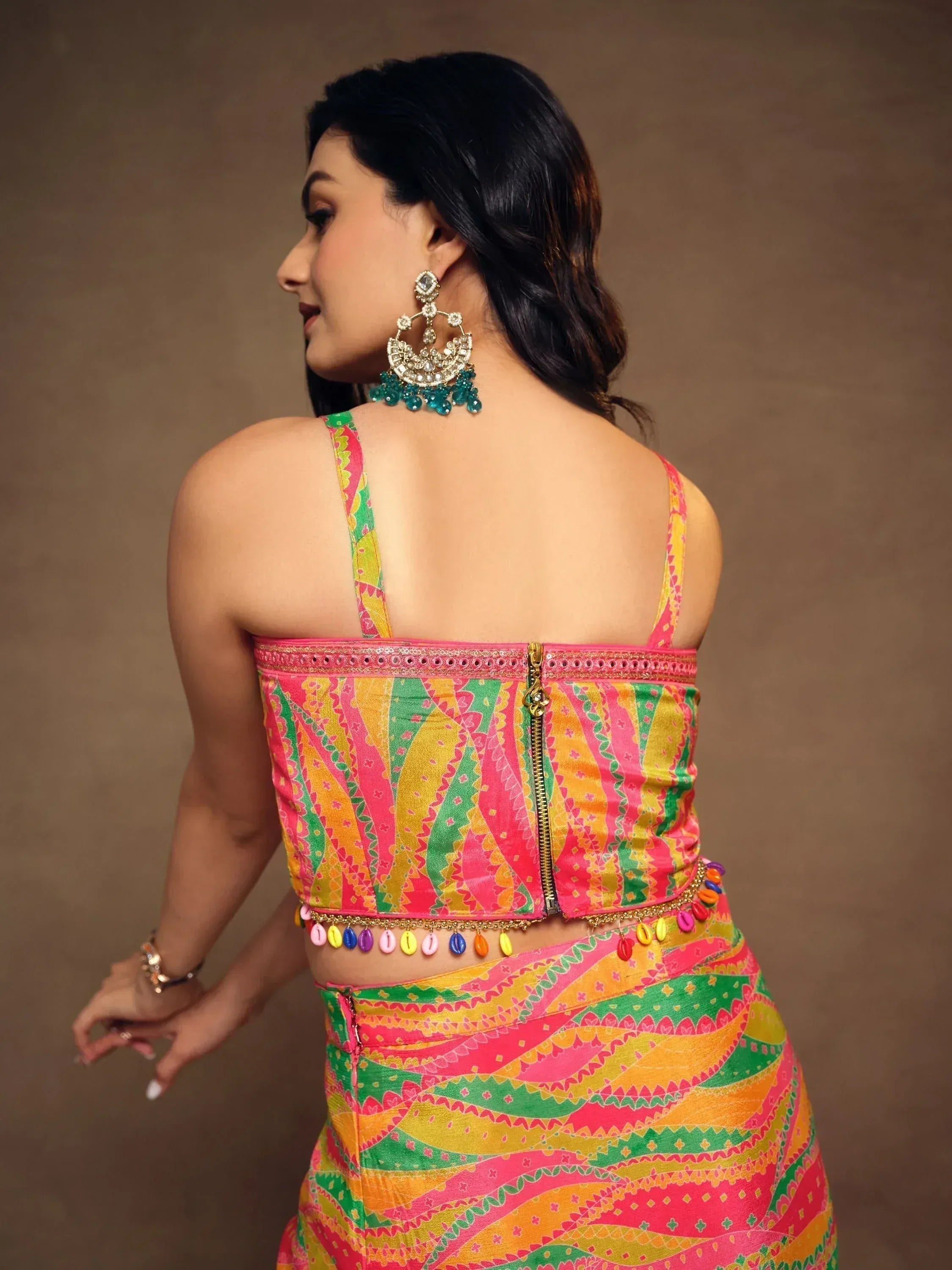 Colorful Indian ethnic lehenga choli with back zipper, pom-pom trim, and statement earrings