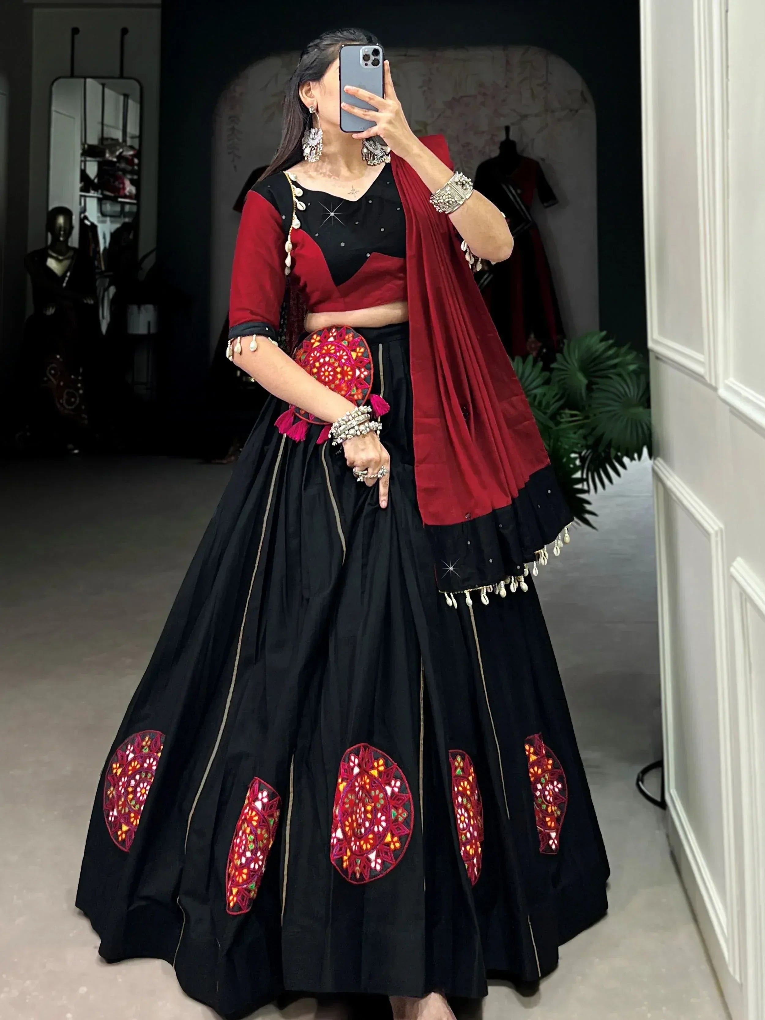 Black and red ethnic lehenga choli with mirror work, perfect for Indian weddings or festive occasions.