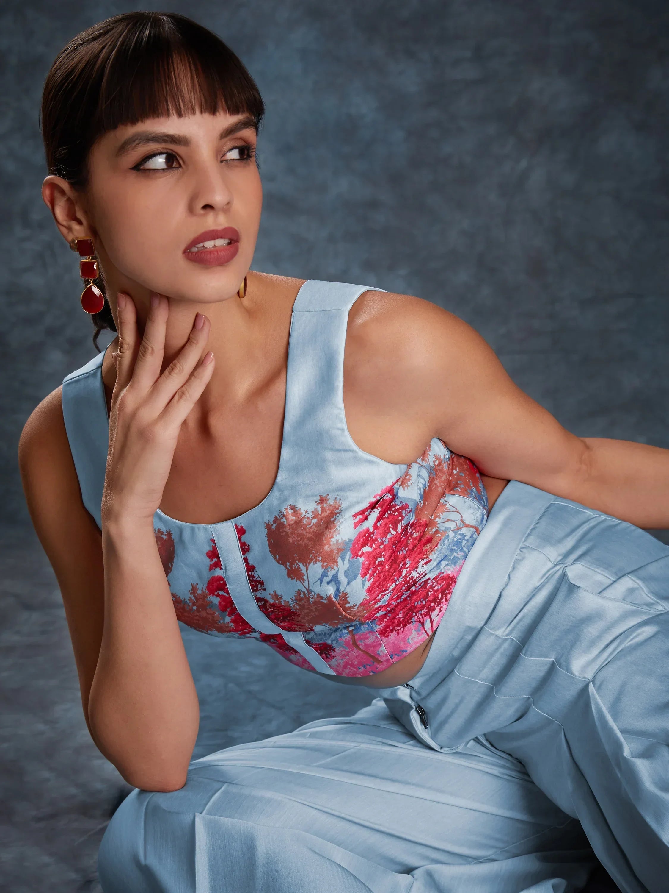 Woman wearing sky blue ethnic wear with floral print crop top, statement red earrings