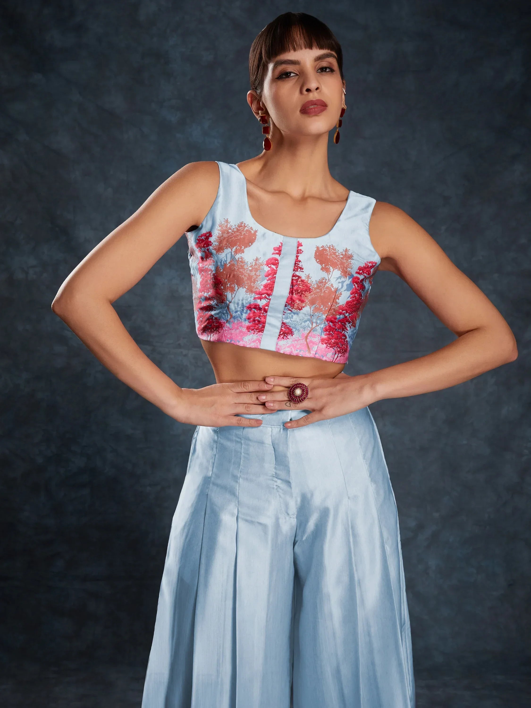 Woman in sleeveless pastel crop top with floral print and light blue ethnic palazzo pants