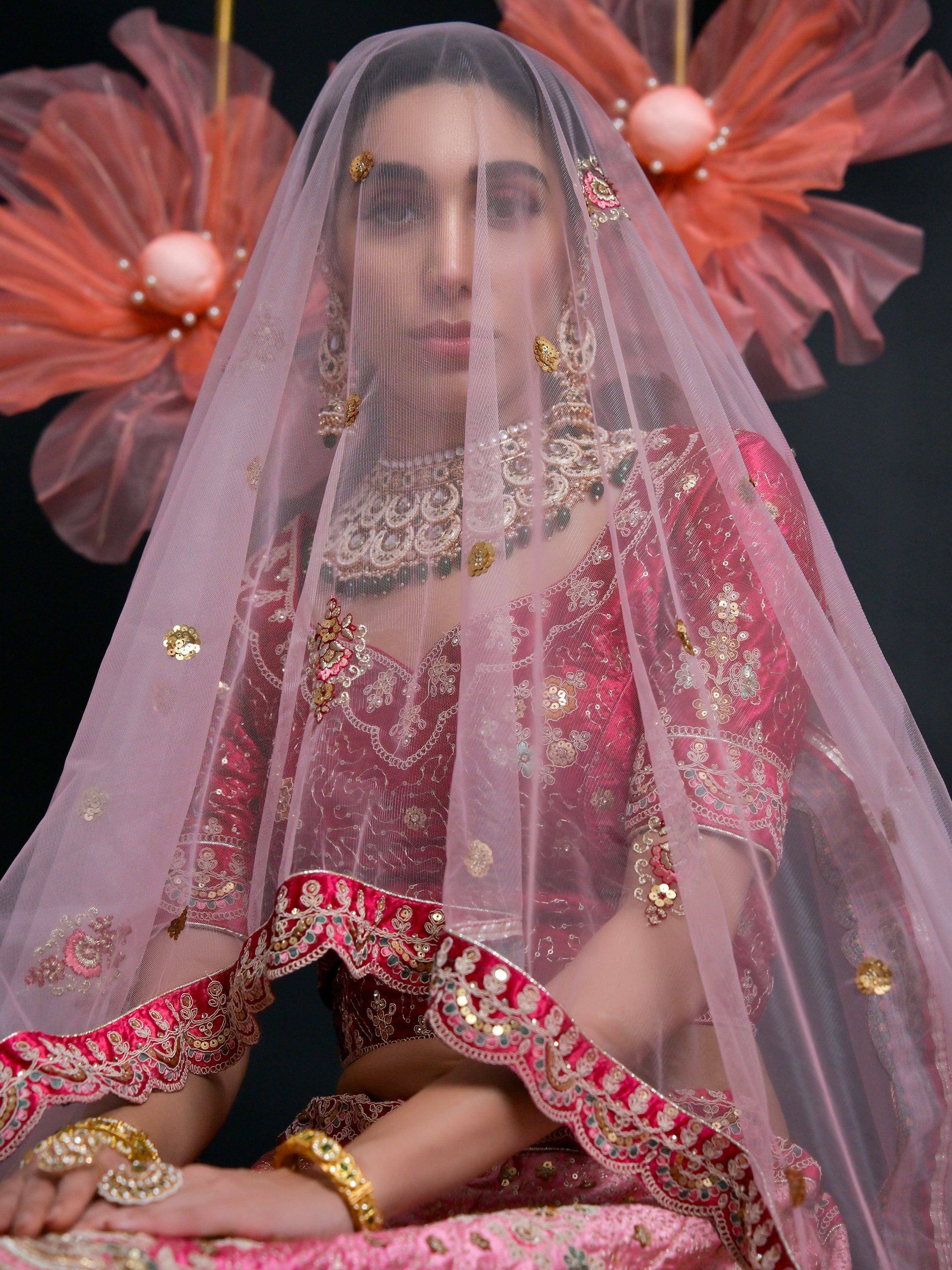 Elegant pink embroidered lehenga choli with sheer dupatta, perfect for Indian weddings and festive occasions.