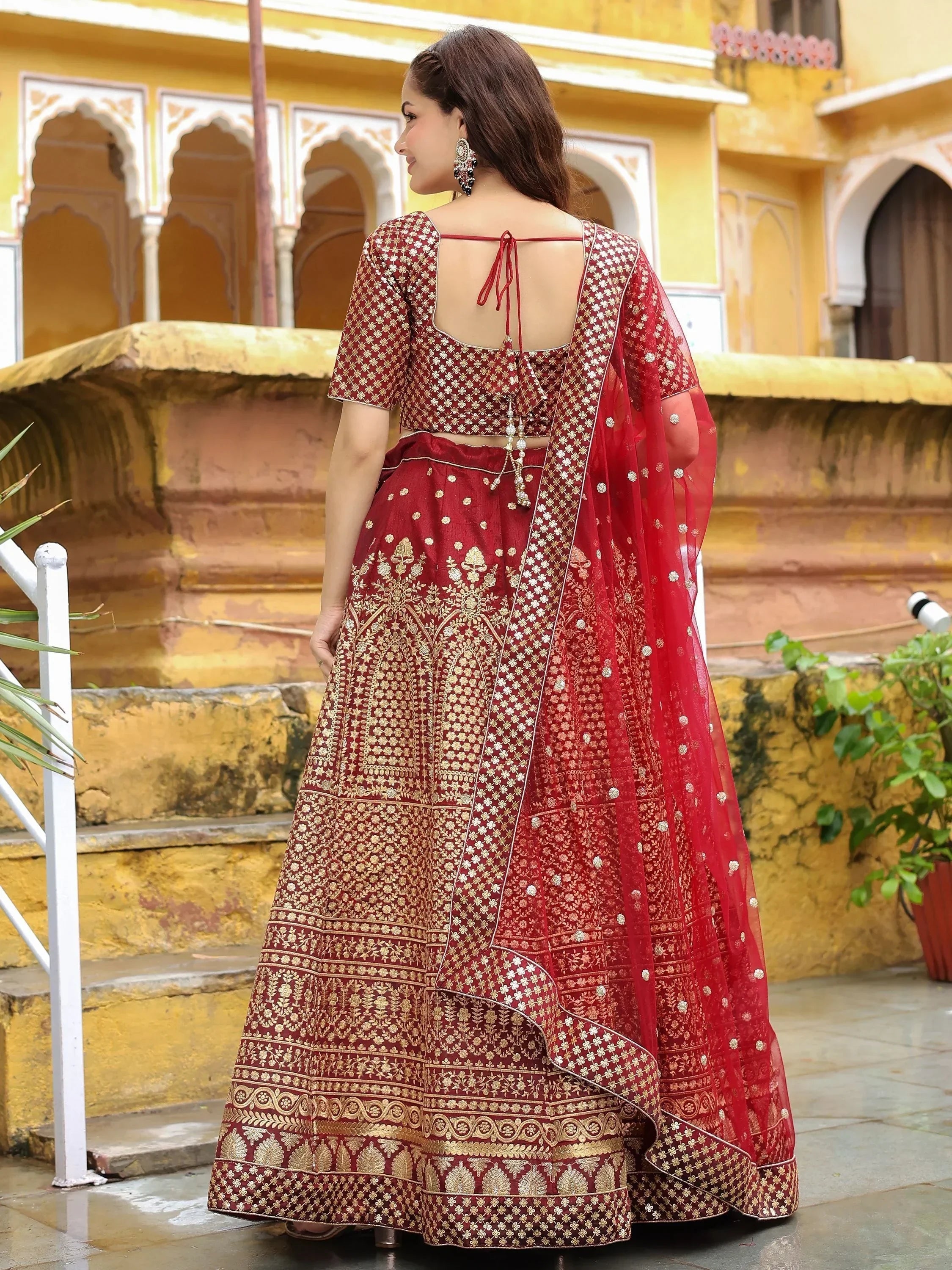 Maroon embroidered lehenga choli with gold detailing, back view, traditional Indian ethnic wear