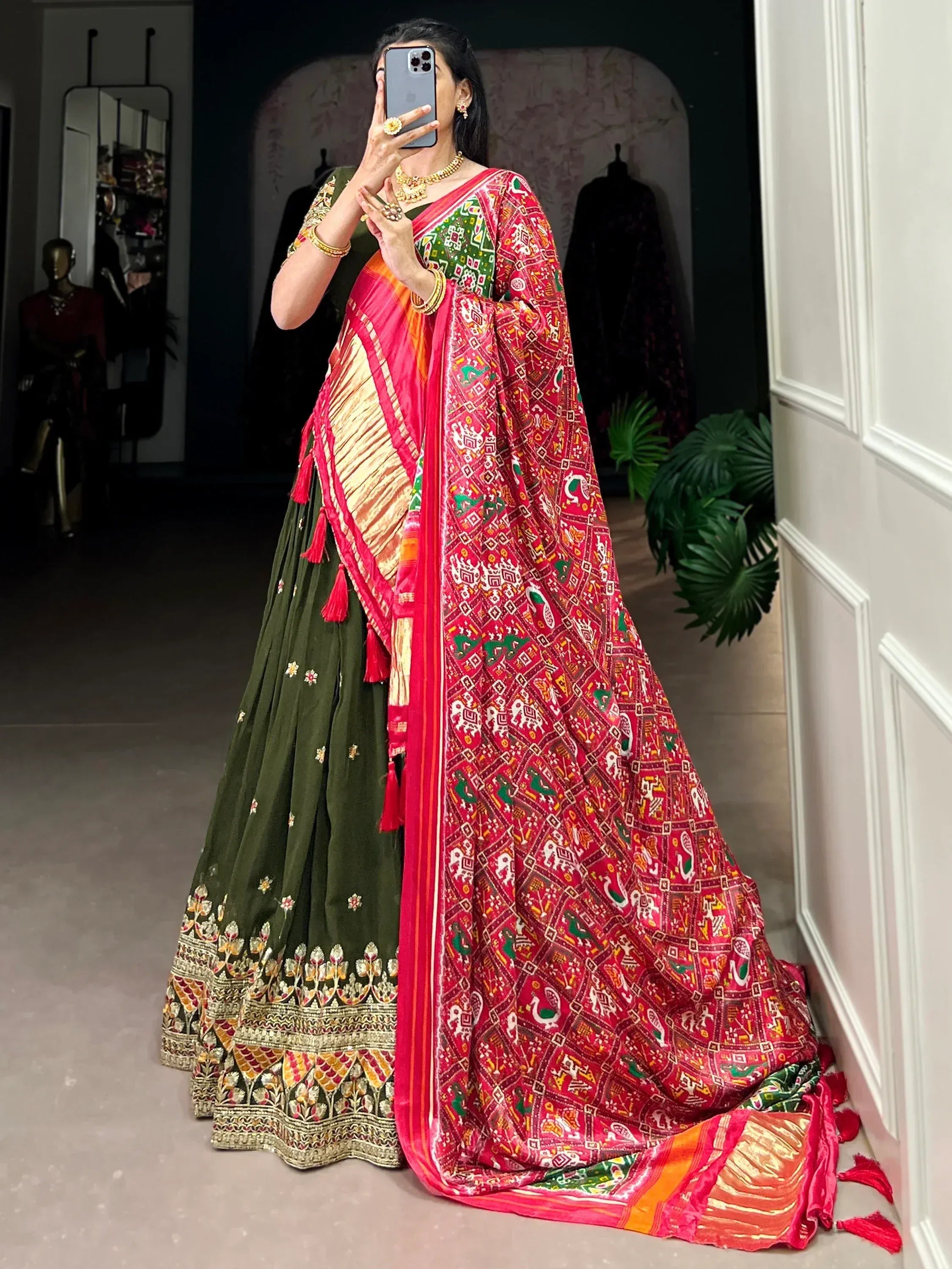 Woman in green lehenga choli with red printed dupatta, ethnic Indian wear for festive occasions
