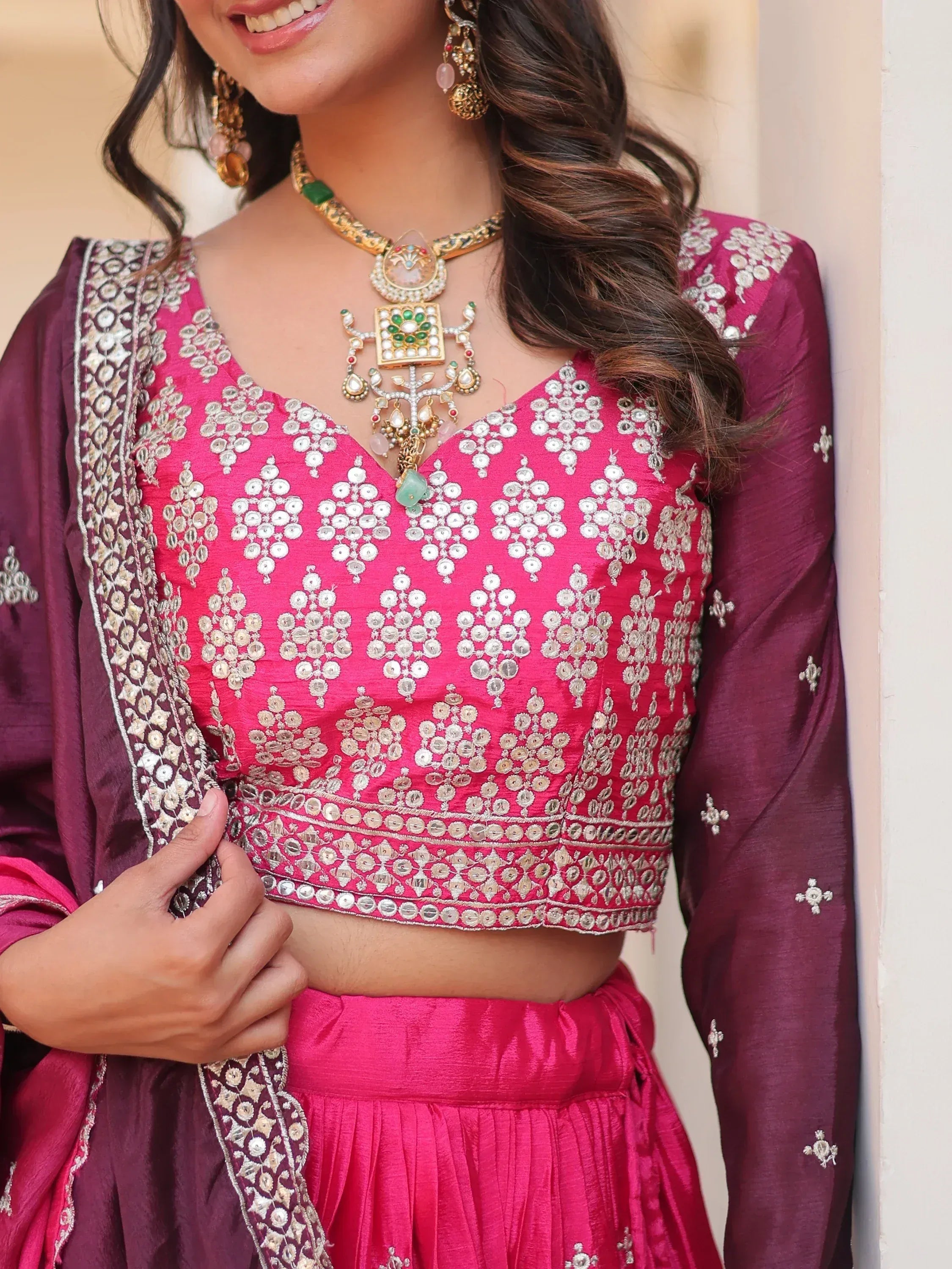 Pink and maroon ethnic lehenga choli with mirror work and traditional jewelry