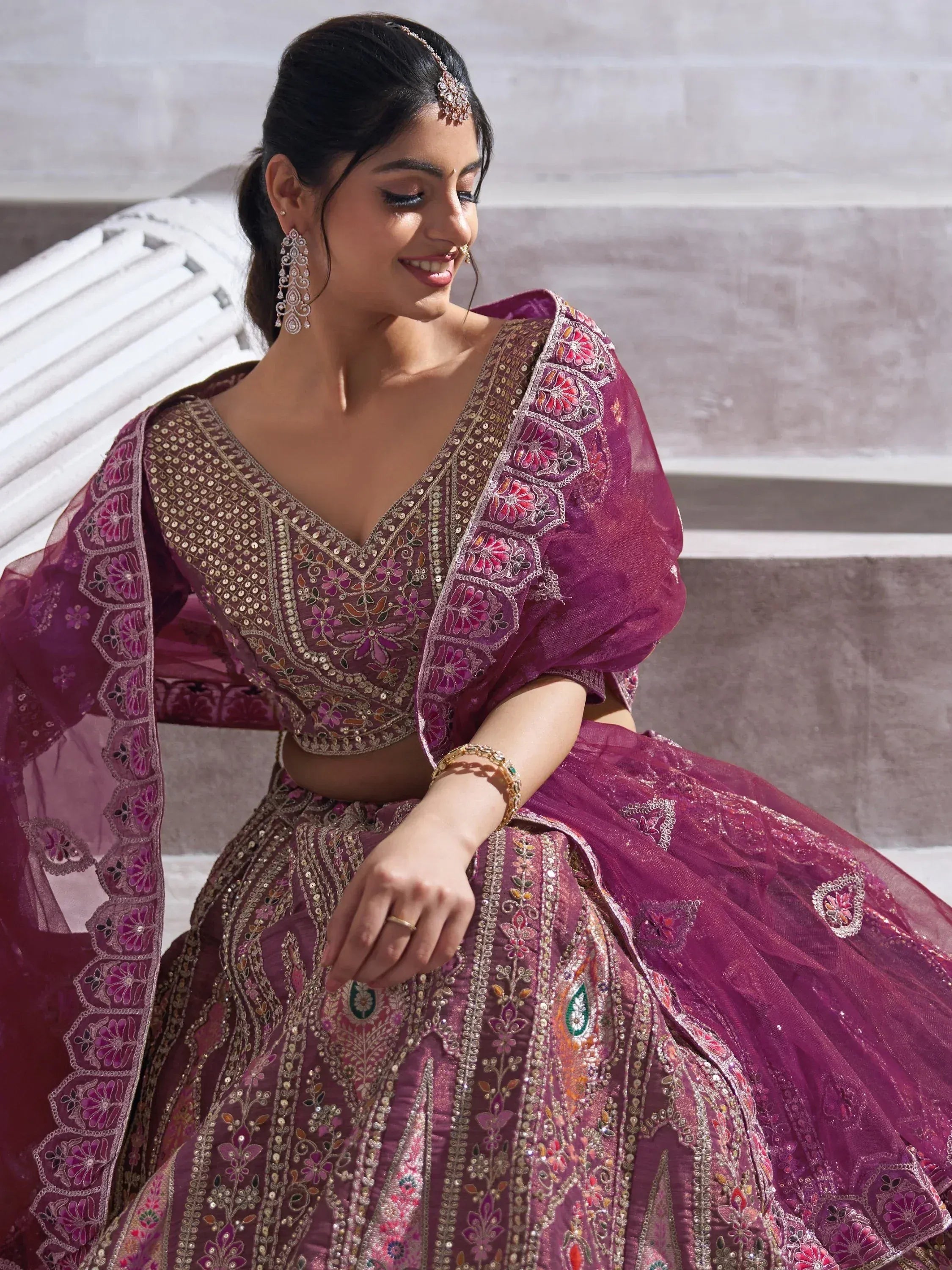 Elegant purple lehenga choli with floral embroidery and mirror work, perfect for Indian weddings and festive occasions.