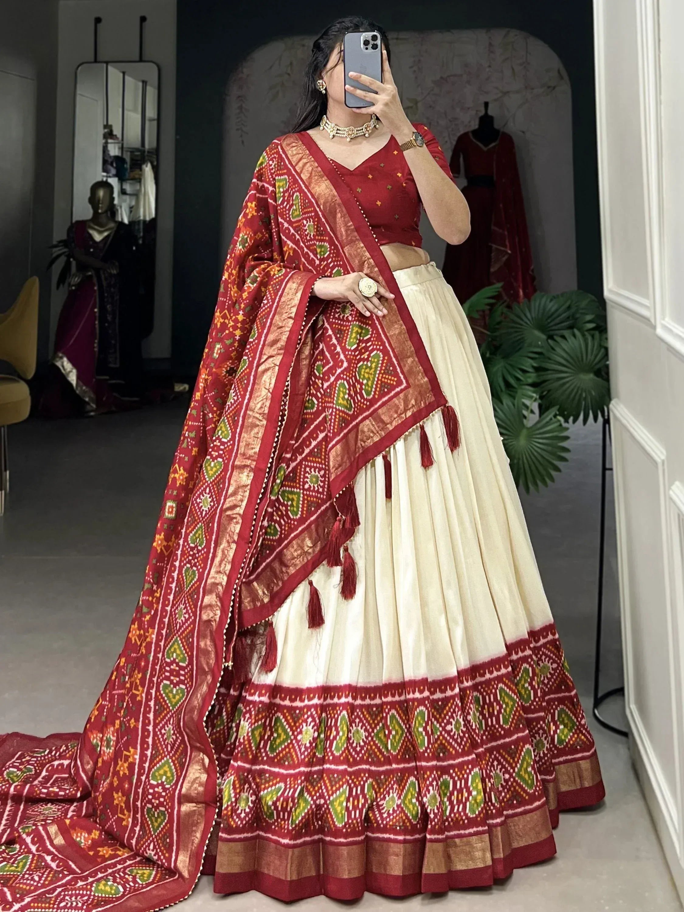 Red and cream ethnic lehenga choli with intricate block print and tassels, perfect for Indian weddings or festivals.