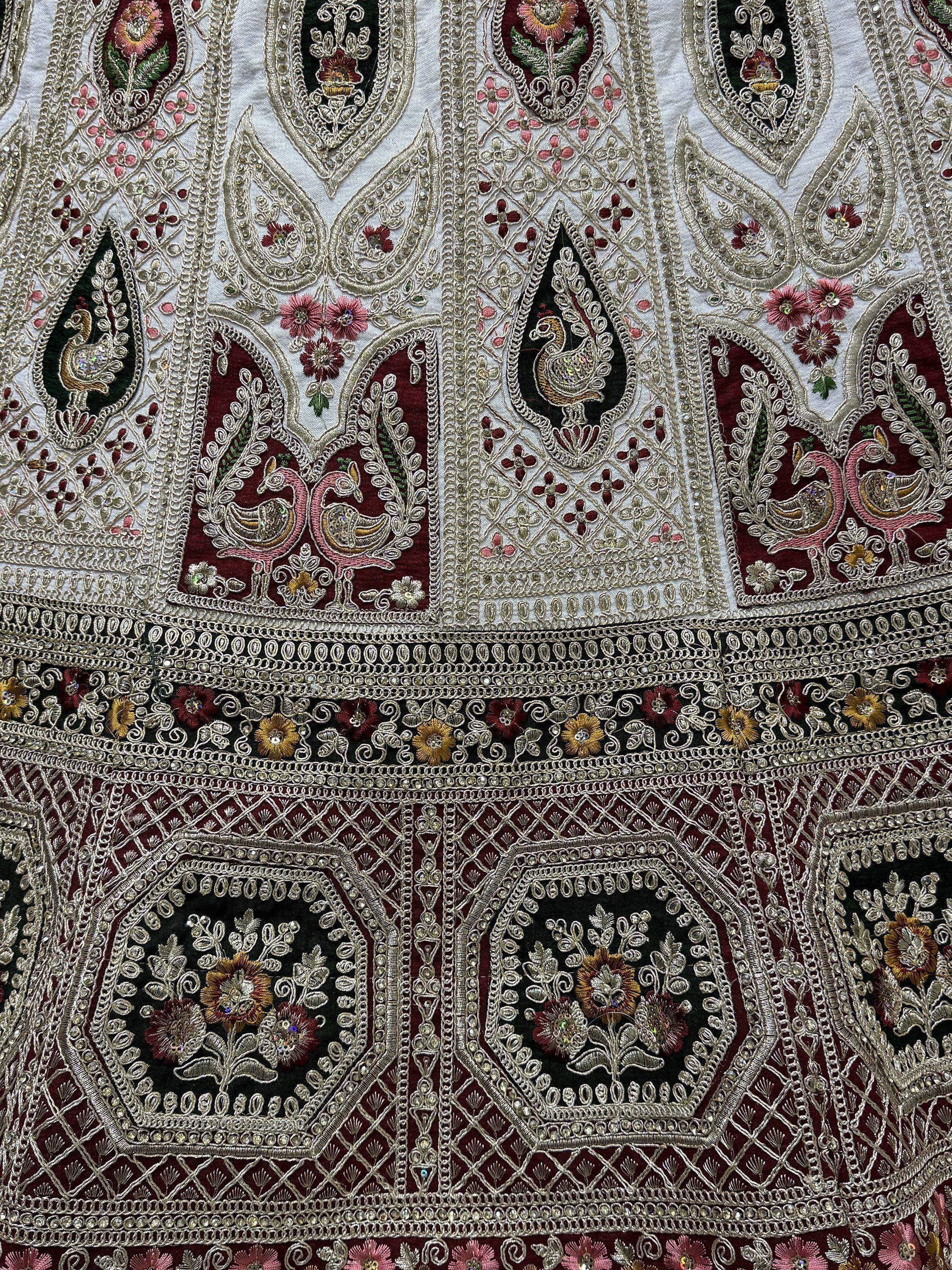 Intricate Indian ethnic wear with peacock embroidery, floral motifs, and detailed zari work on velvet fabric.