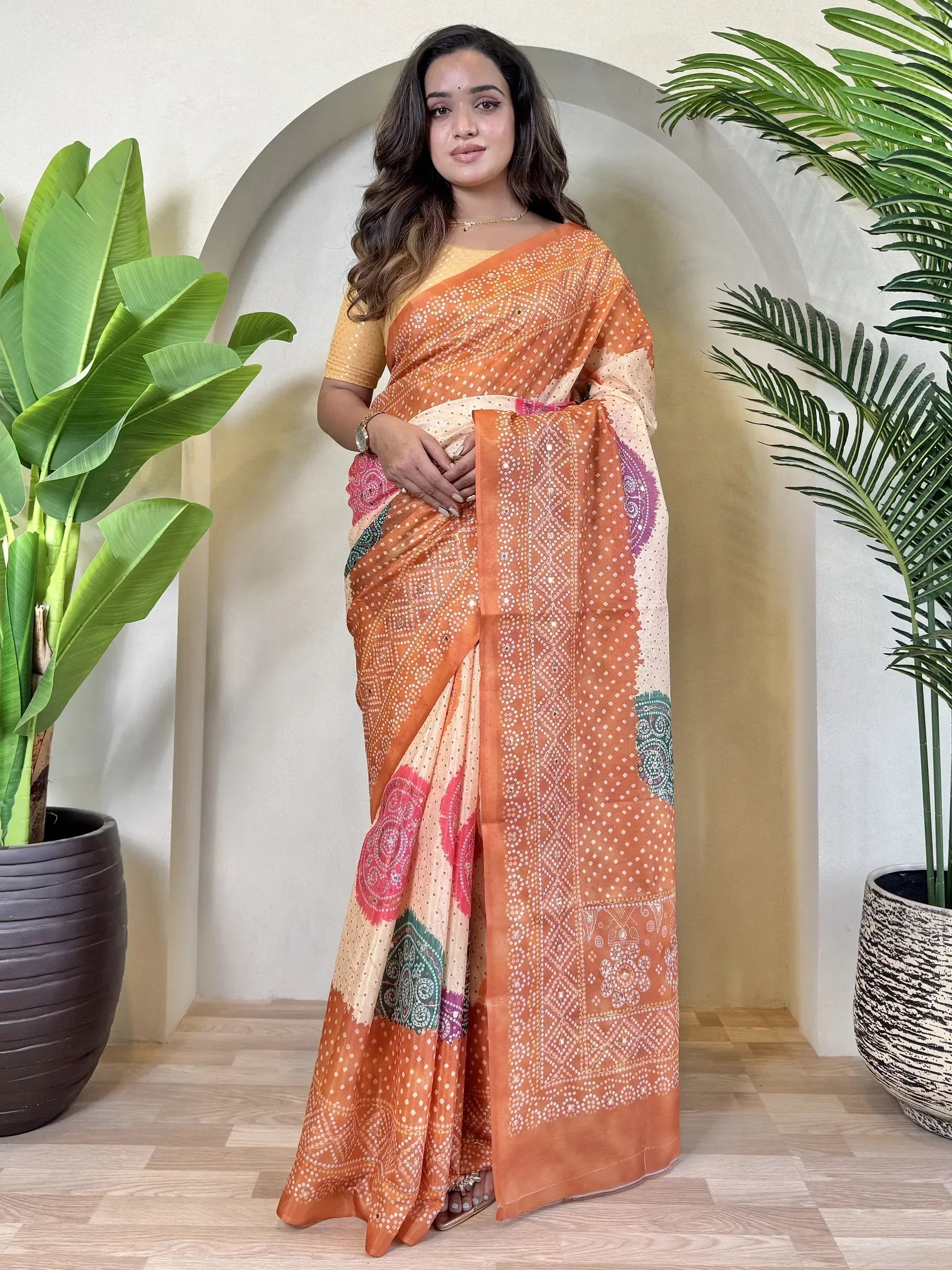 Orange printed saree with ethnic patterns, paired with yellow blouse, perfect for Indian occasions